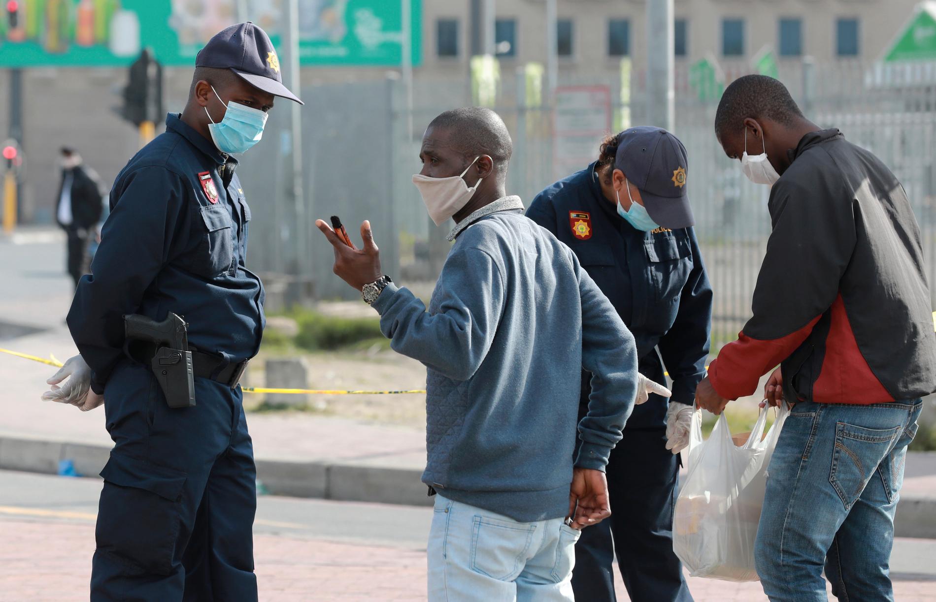Sydafrikansk polis kontrollerar tillstånd vid en väntplats för taxibilar utanför Kapstaden.