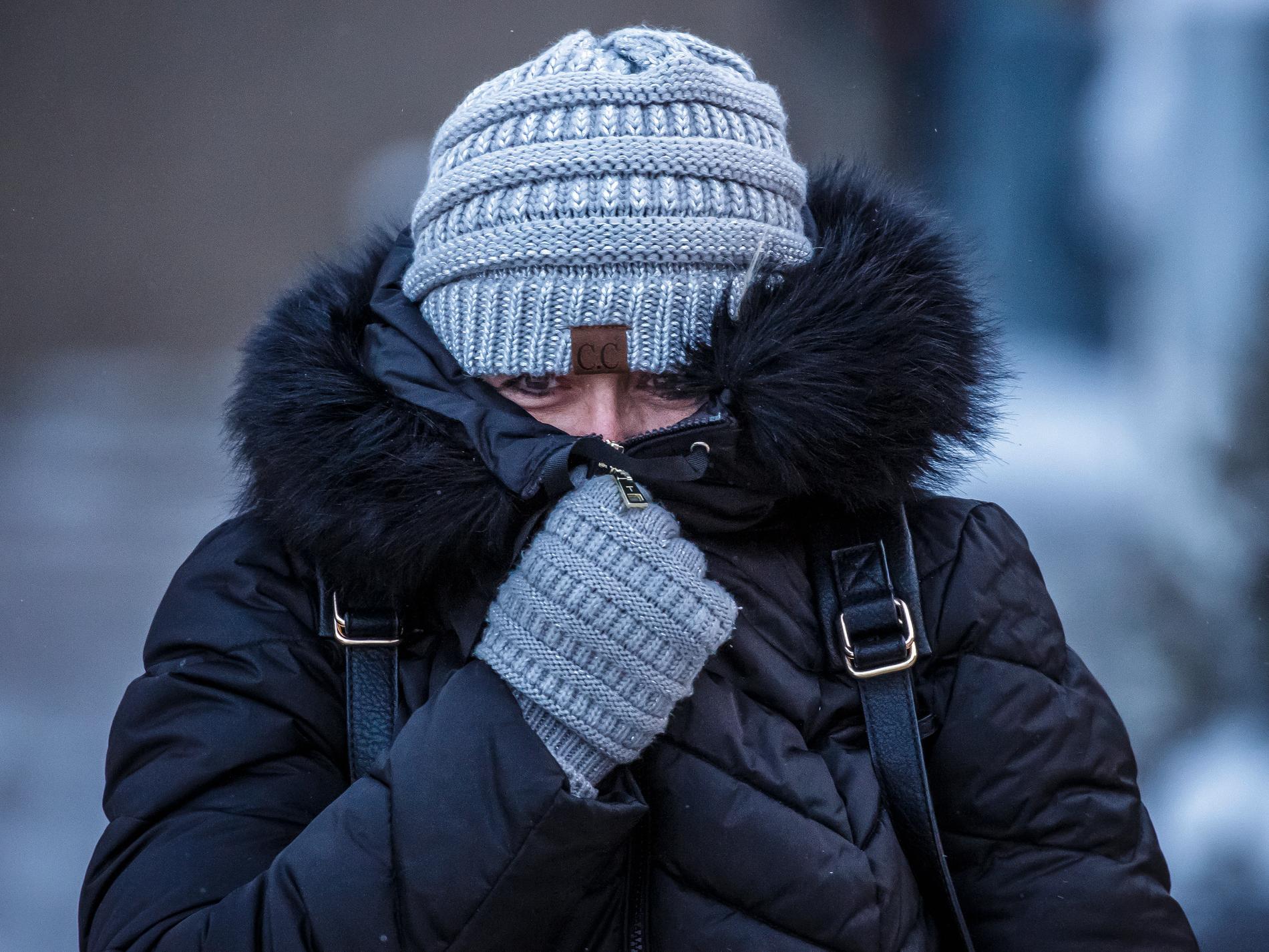 En kvinna i Rochester i Minnesota skyddar ansiktet mot kylan under en kort promenad på tisdagen. I flera stater i den amerikanska mellanvästern väntas de lägsta temperaturerna på flera generationer de kommande dagarna.