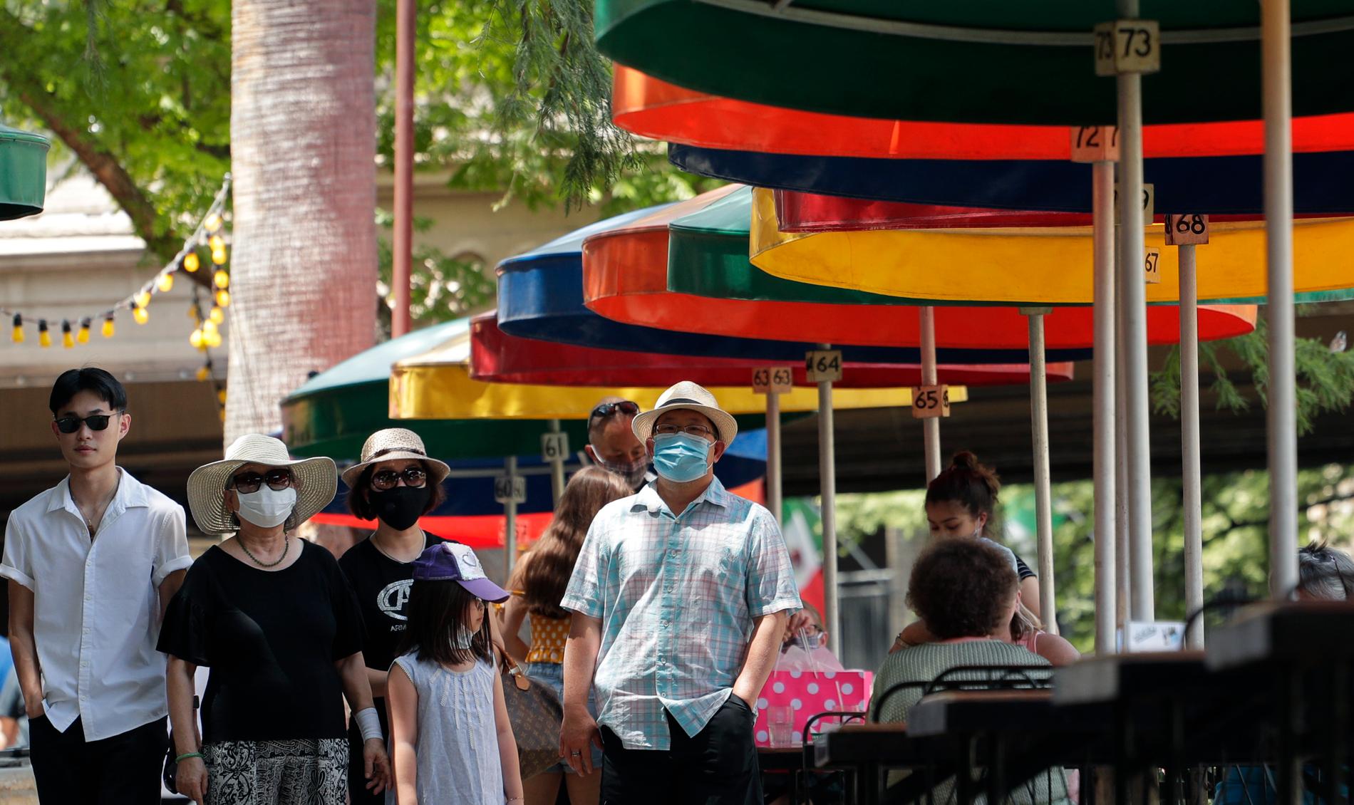 Besökare med munskydd strosar i San Antonio i Texas, en av de USA-delstater där smittspridningen av det nya coronaviruset nu ökar.