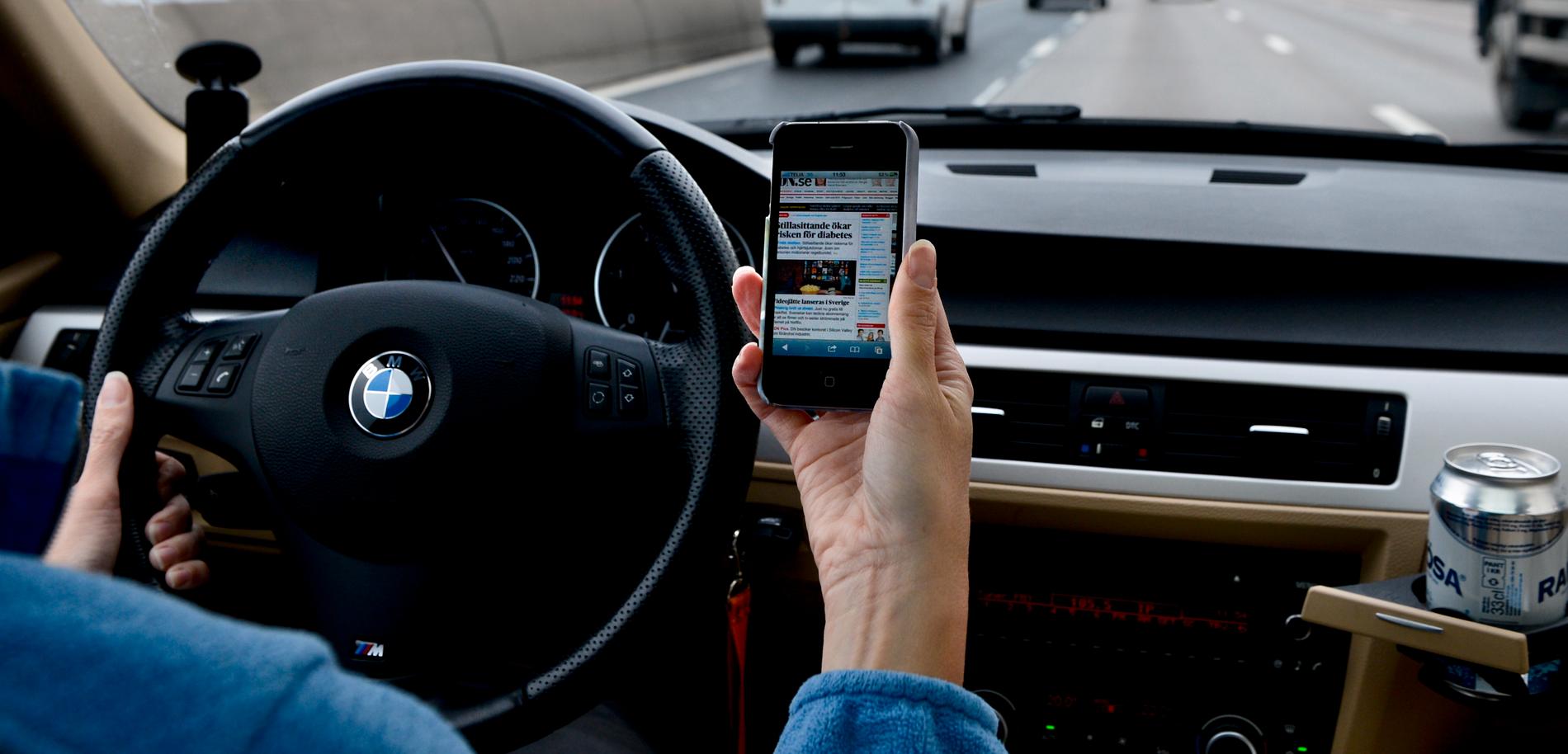 Numera är det förbjudet att hålla telefonen i handen samtidigt som man kör. Arkivbild.