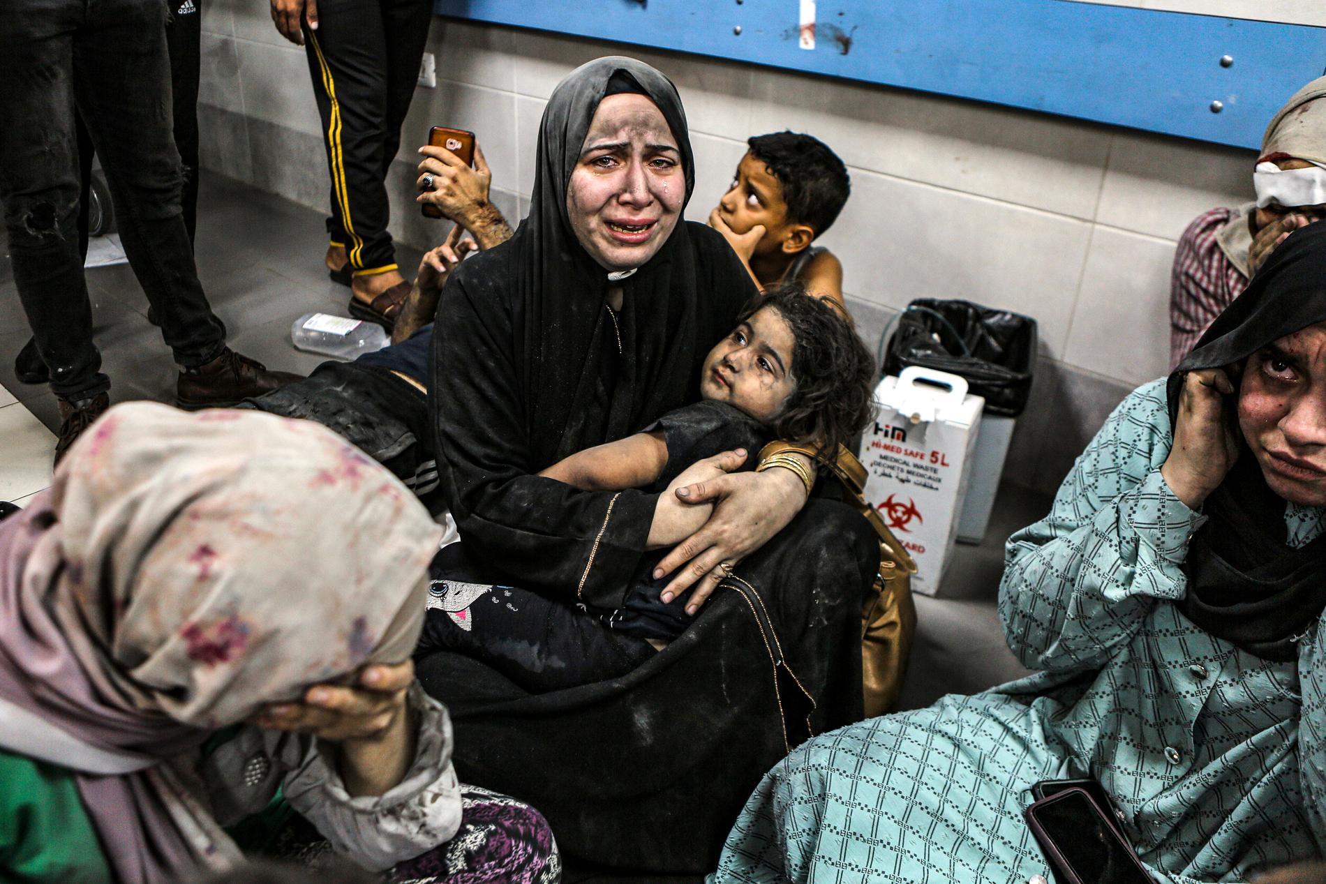  Sårade palestinier sitter på al-Shifa-sjukhuset i Gaza City, centrala Gazaremsan, efter att ha anlänt från al-Ahlis sjukhus efter en explosion.