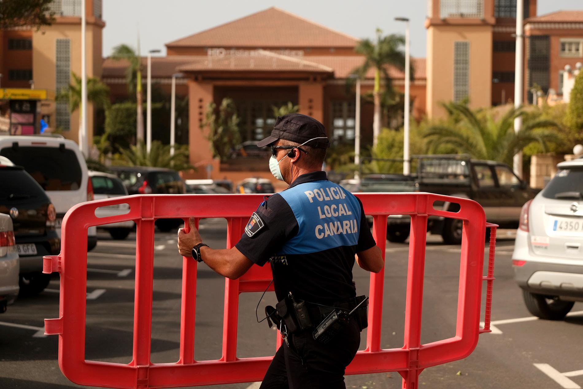 En spansk polis spärrar av ett hotell på Teneriffa. Omkring 1 000 hotellgäster har satts i karantän på den spanska ön.