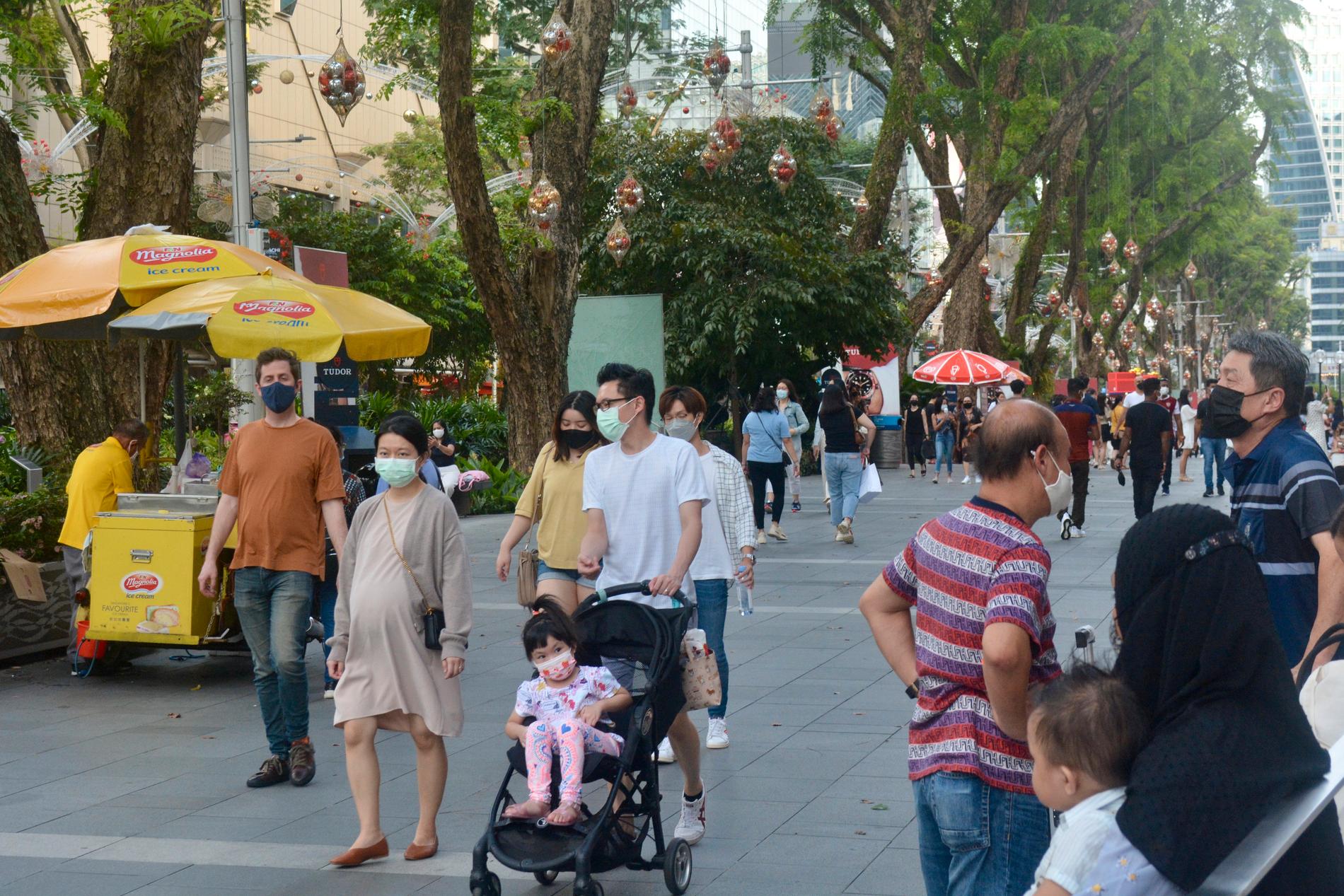 Människor med munskydd på shoppinggatan Orchard Road i Singapore.