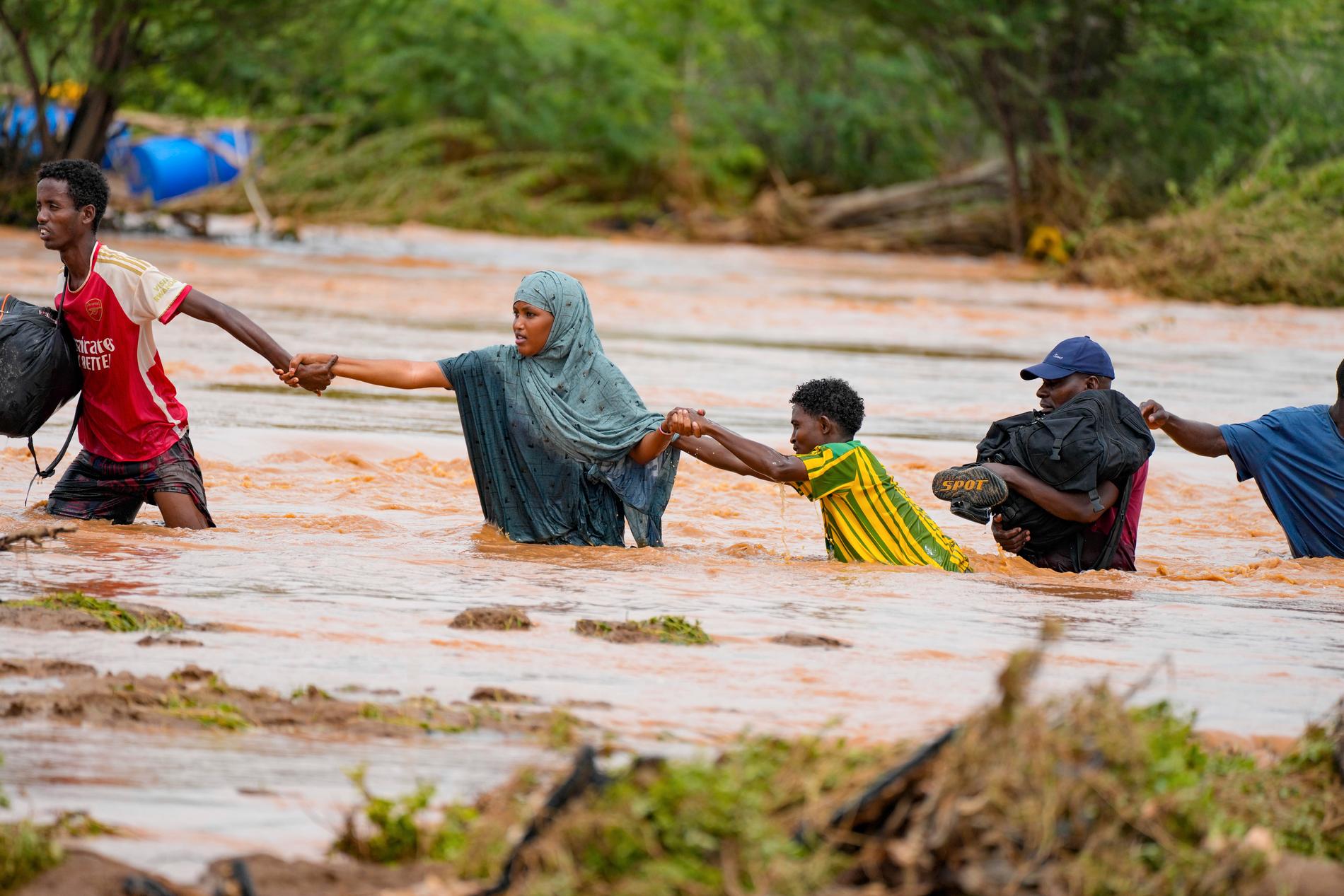 Människor försöker ta sig över floden Tana i Kenya efter översvämningar liknande dem söder om gränsen till Tanzania. Bild från förra veckan.