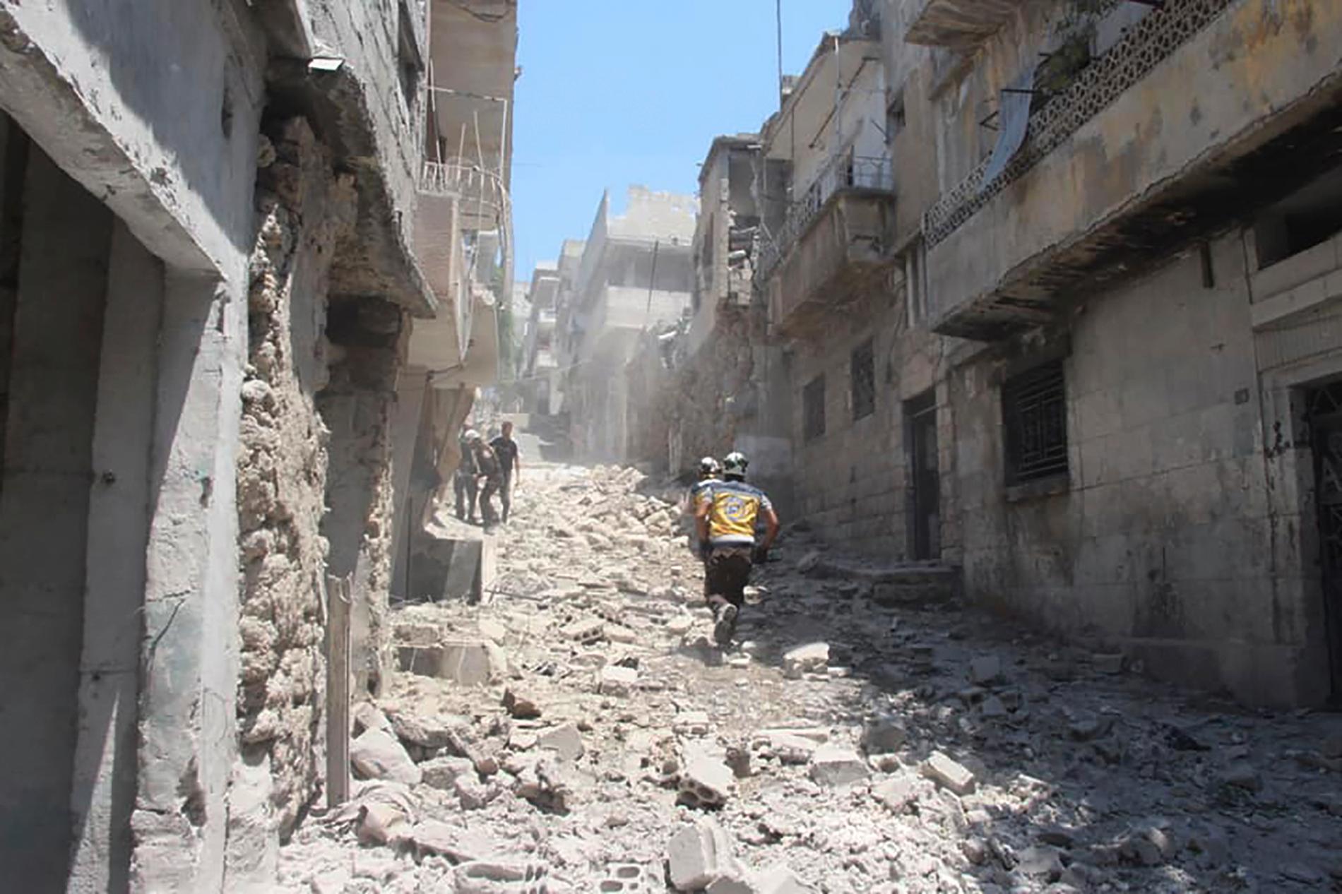 Hjälparbetare springer på en gata i Idlibprovinsen efter ett syriskt bombanfall. Bilden har tagits av den syriska hjälporganisationen Vita hjälmarna. Arkivbild