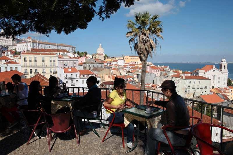 Här sitter turisterna och njuter av utsikten i Lissabon. 