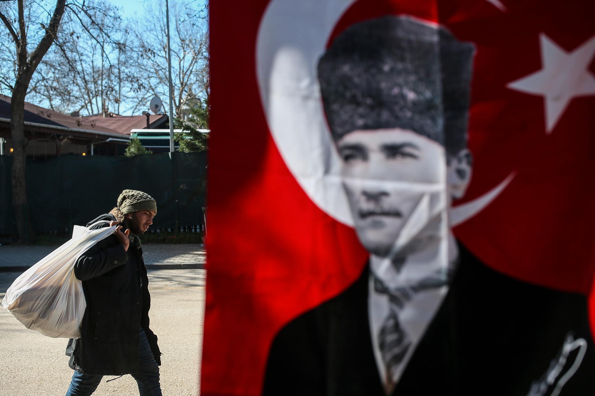 Migrant passerar bild på moderna Turkiets grundare Kemal Atatürk i Edirneregionen, nära Grekland. Arkivbild.