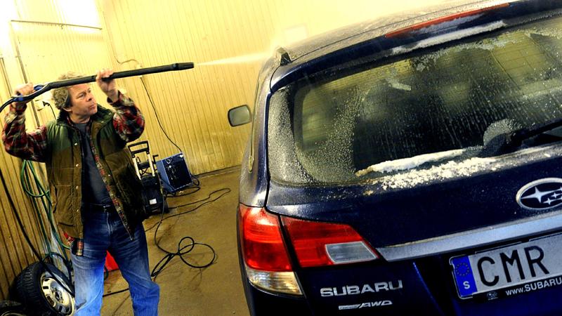 Robert smeker bilarna med högtryckstvätten för att de ska vara rena och fina på bild. Foto: Lasse Allard