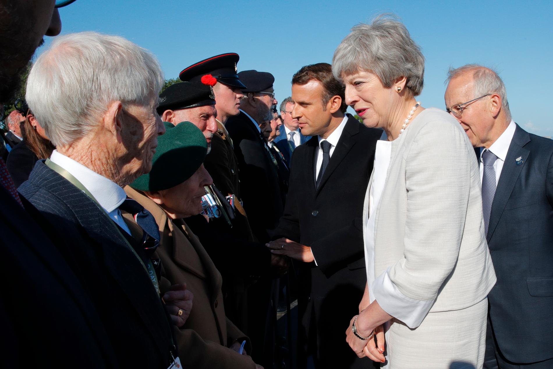 Storbritanniens premiärminister Theresa May och Frankrikes president Emmanuel Macron hälsar på veteraner som var med under D-dagen den 6 juni 1944.