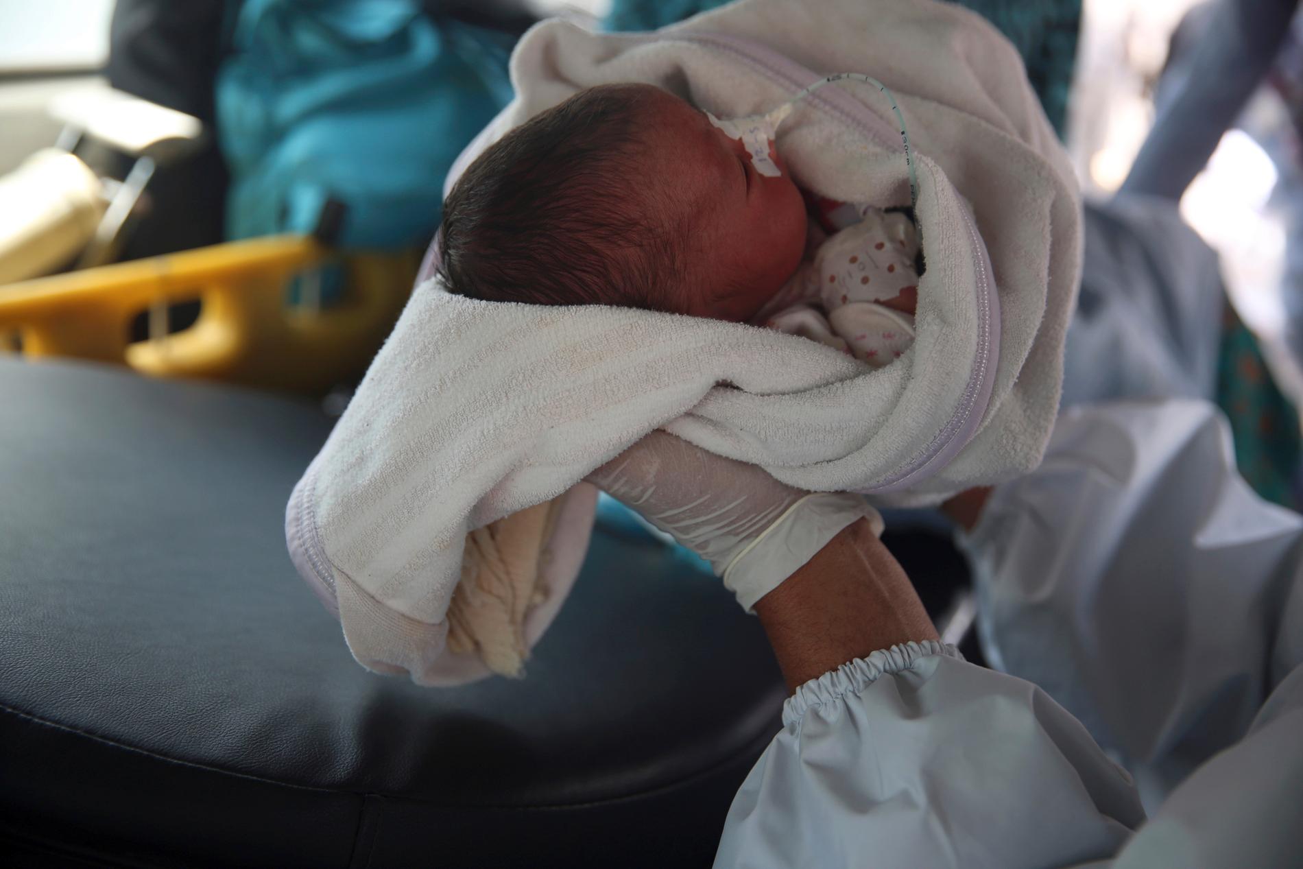 En bebis förs i väg med ambulans efter attacken mot förlossningskliniken i Kabul i tisdags.