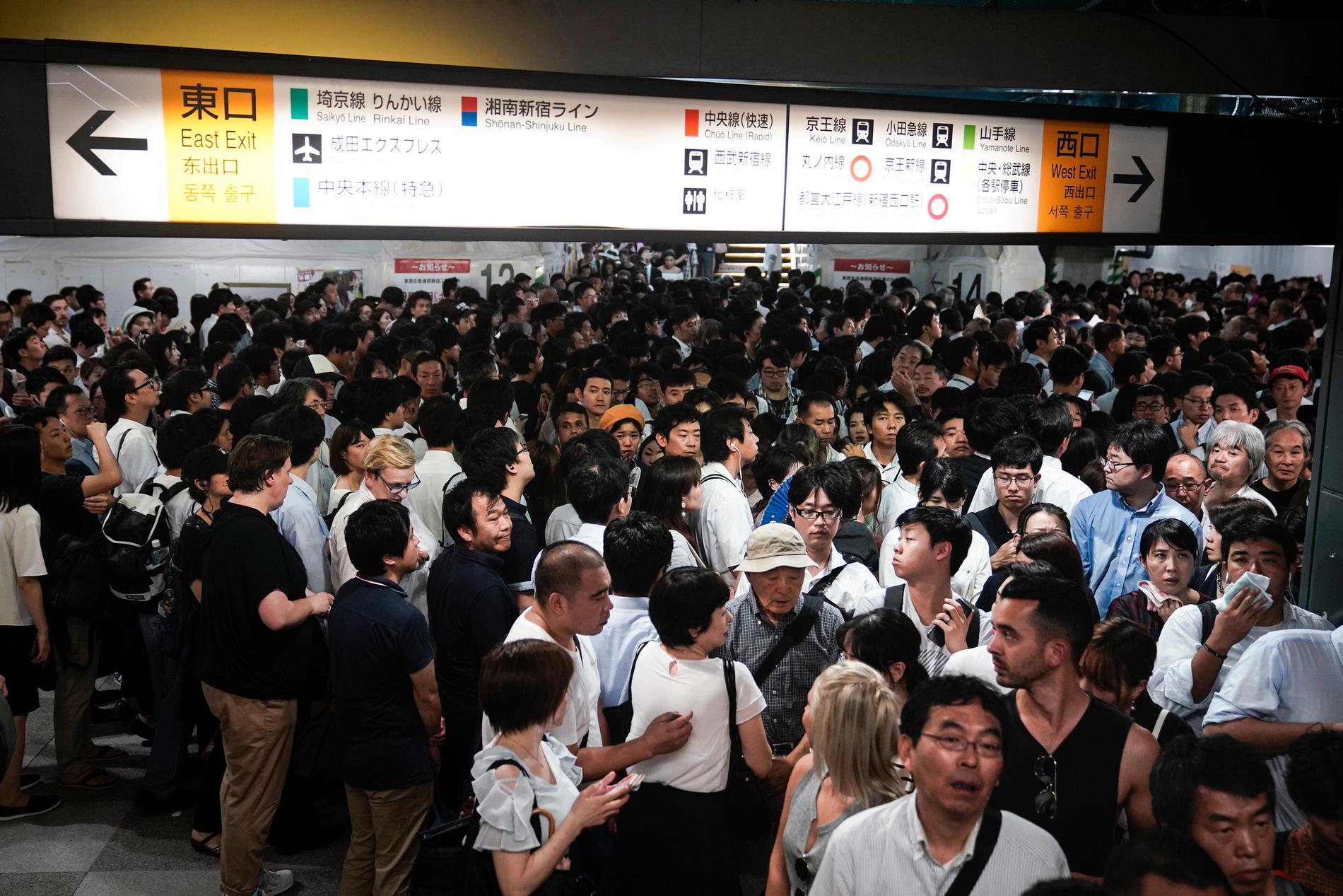 Passagerare vid Shinjukustationen i Tokyo väntar på att tågen ska börja rulla igen.