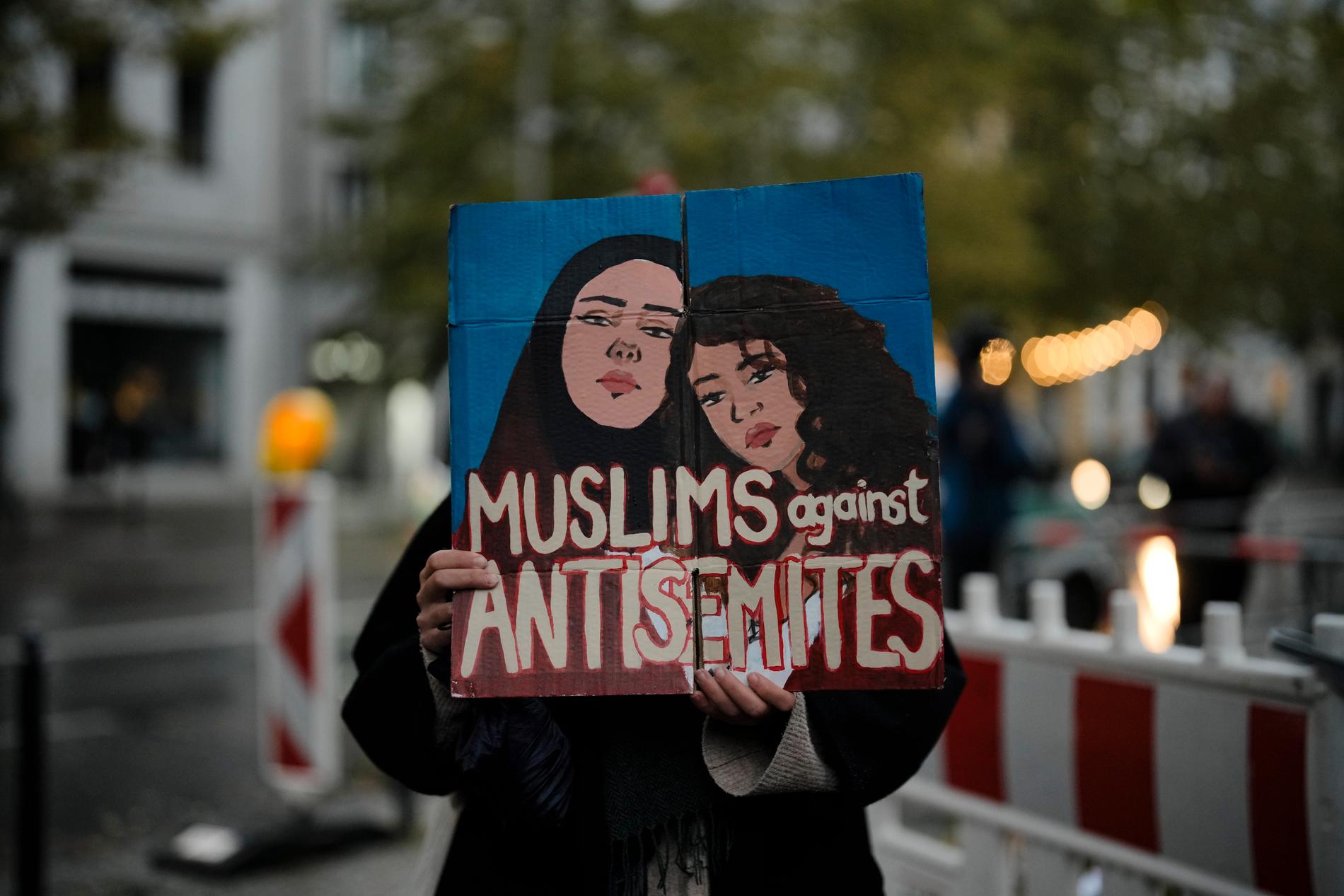 En muslimsk kvinna håller upp ett plakat mot antisemitism under en manifestation i Berlin den 20 oktober. Arkivbild.