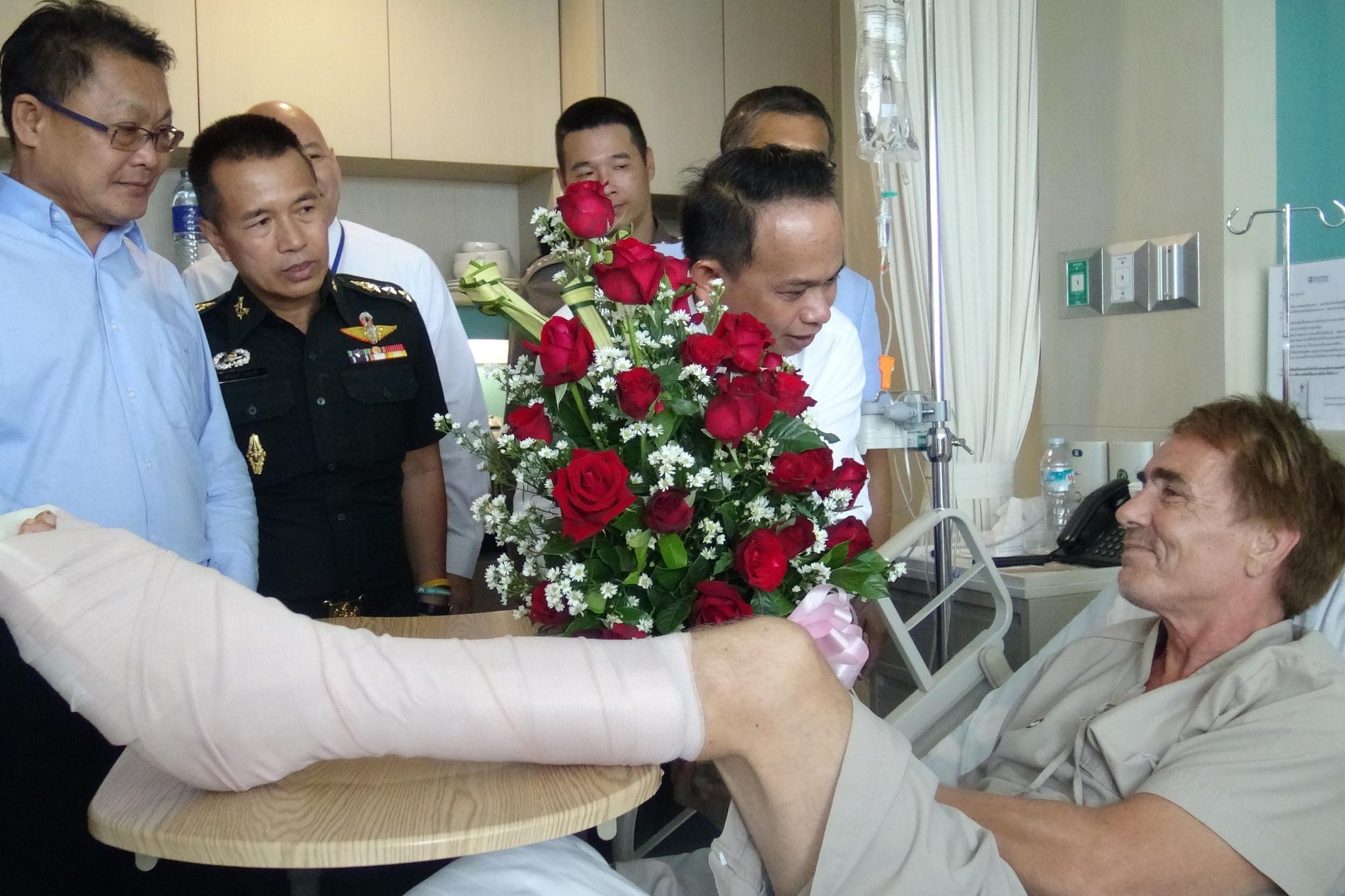 Norrmannen Werner Danielsen uppvaktas på sjukhuset av thailändska myndighetspersoner sedan han blivit attackerad av en haj i Hua Hin.