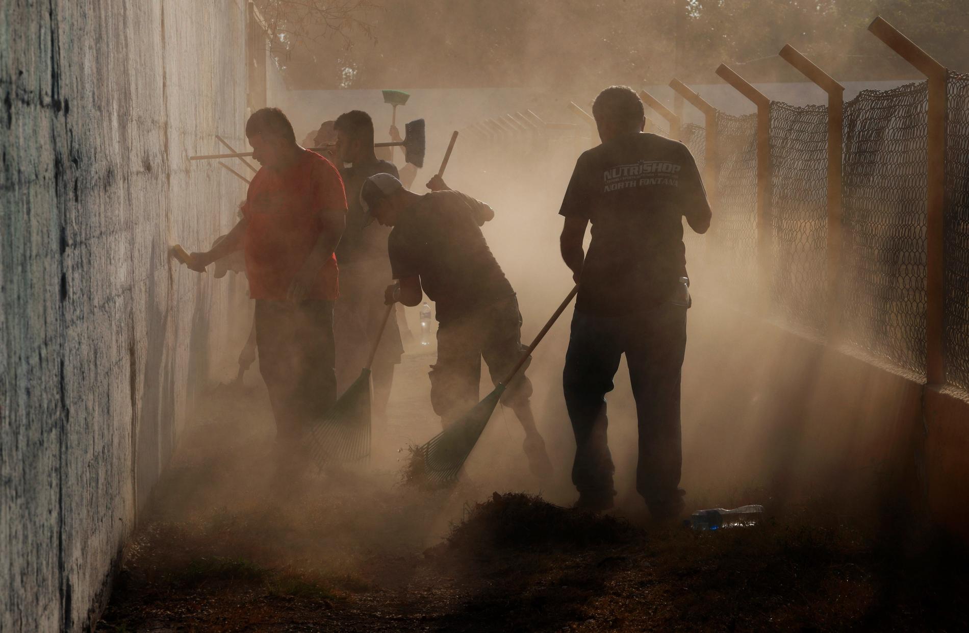 Centralamerikanska migranter som beviljats uppehållstillstånd av humanitära skäl arbetar med att städa en sportarena i Mexiko.