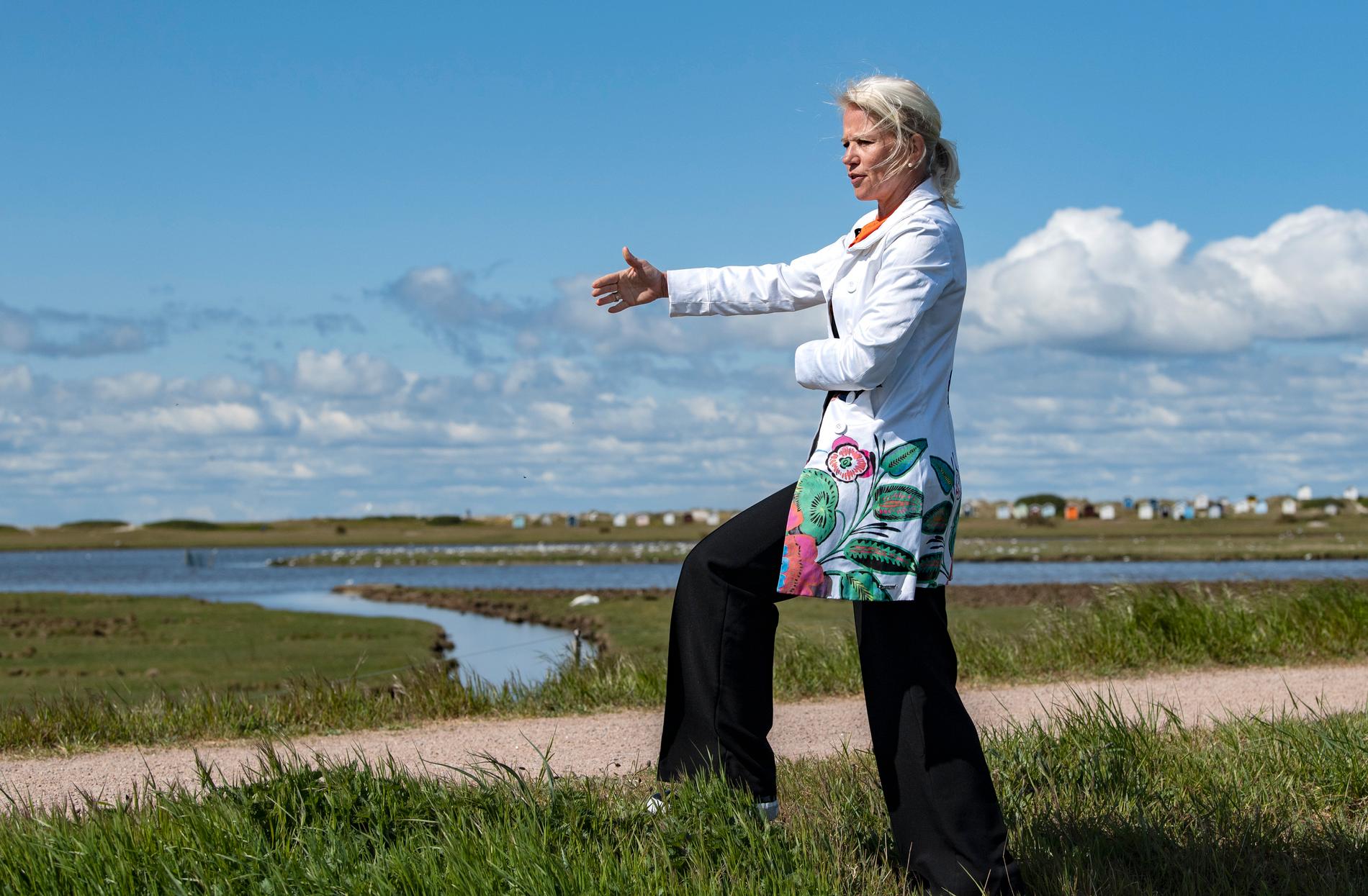 Kommunstyrelsens ordförande Carina Wutzler (M) vid den skyddsvall som redan finns på plats i Skanör. Wutzler ser översvämningsskyddet som en ödesfråga för Falsterbonäset.