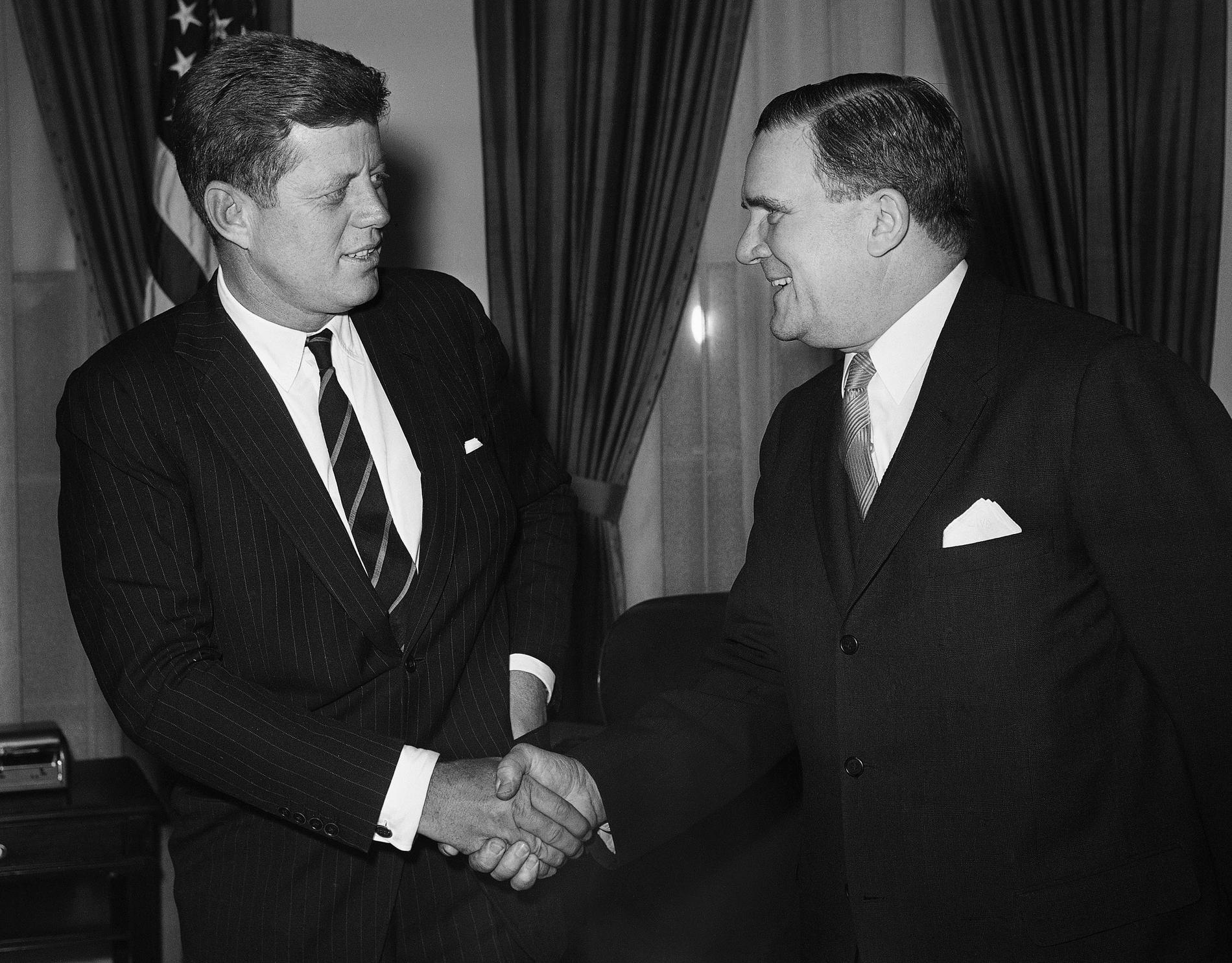 Den nyutnämnde Nasachefen James E. Webb skakar hand med president John Kennedy vid en ceremoni den 30 januari 1961. Arkivbild.
