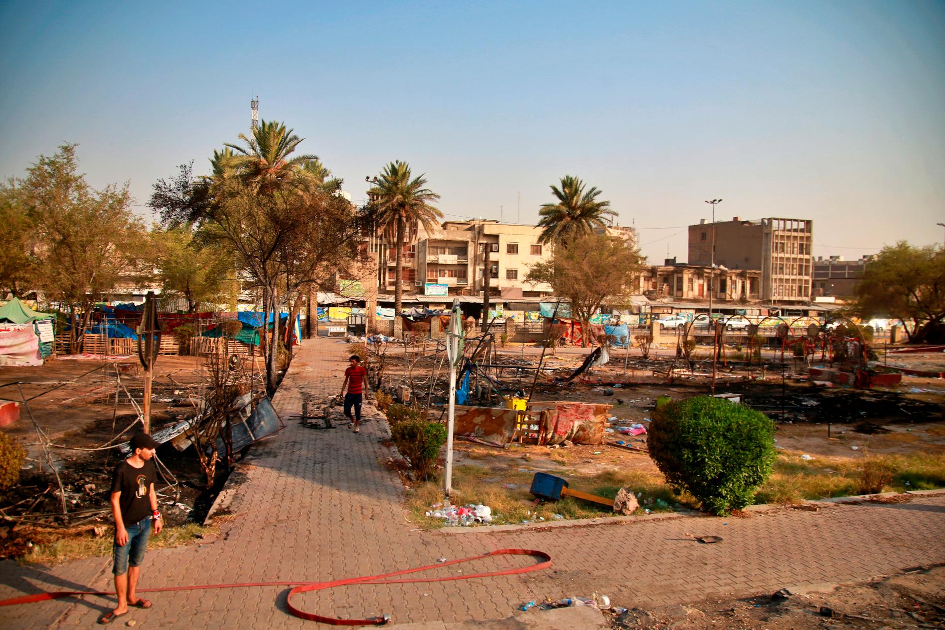 Demonstranter inspekterar nedbrända tält i närheten av Tahrirtorget i Bagdad efter de nya protesterna.