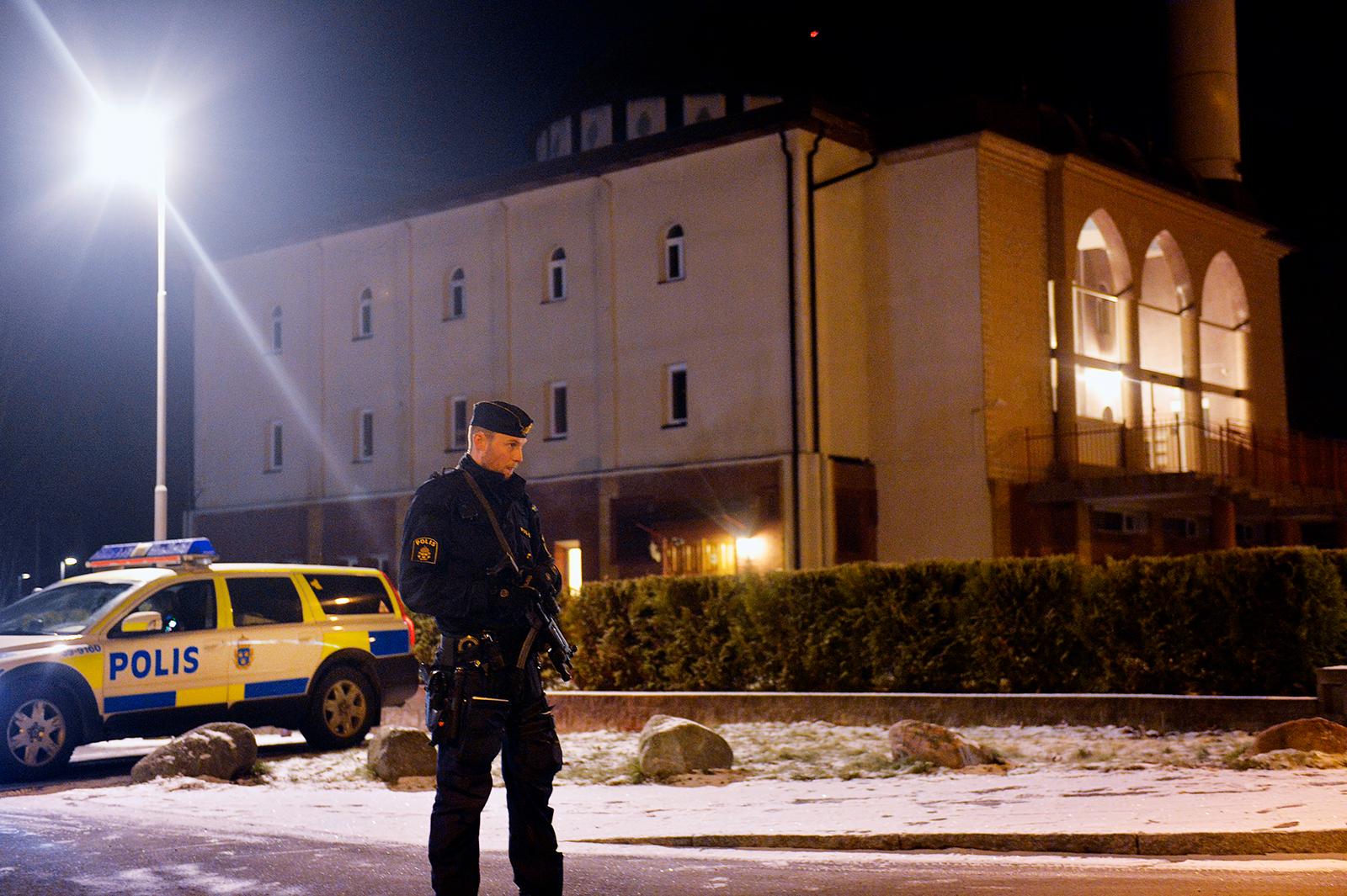 Polisen står utanför moskén med förstärkningsvapen.