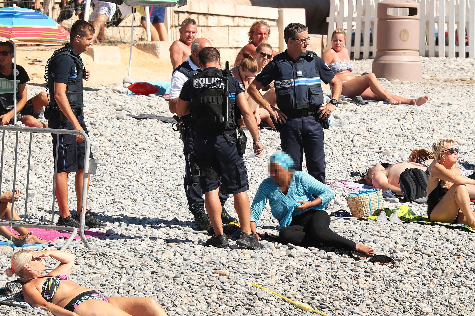 Poliserna hotade kvinnan med pepparsprej och bad henne ta av sig huvudduken.