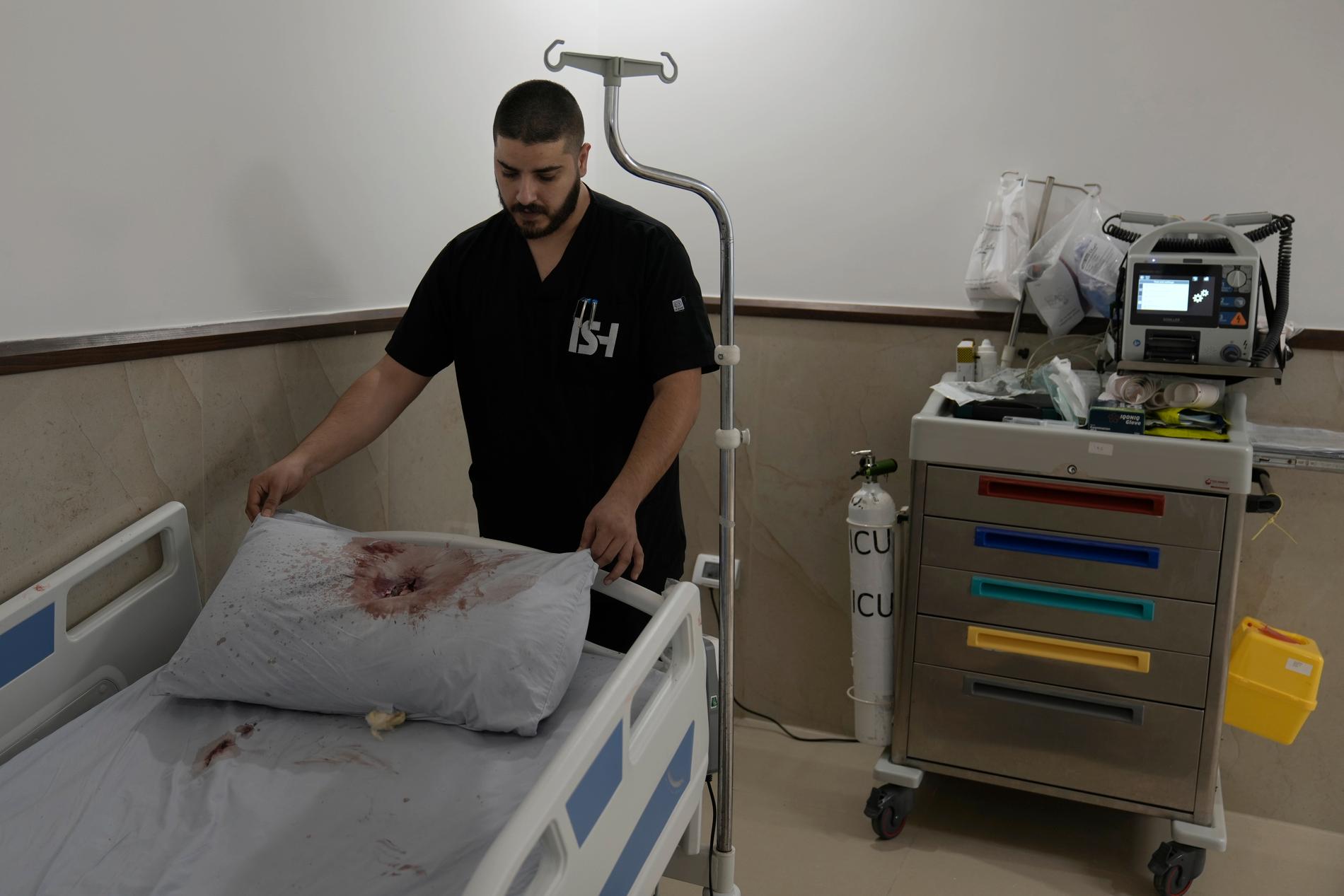 Vårdpersonal på Ibn Sina-sjukhuset i Jenin visar en blodig kudde efter att en israelisk militärräd skett under tisdagen.