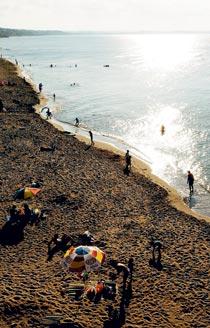 Solen sänker sig över havet och badgästerna packar ihop sina pinaler på stranden i Sinop.