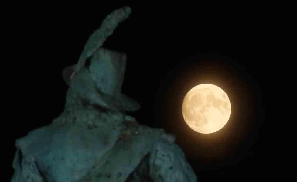 Supermånen går upp bakom statyn av Karl X Gustav på Stortorget i Malmö på söndagskvällen.