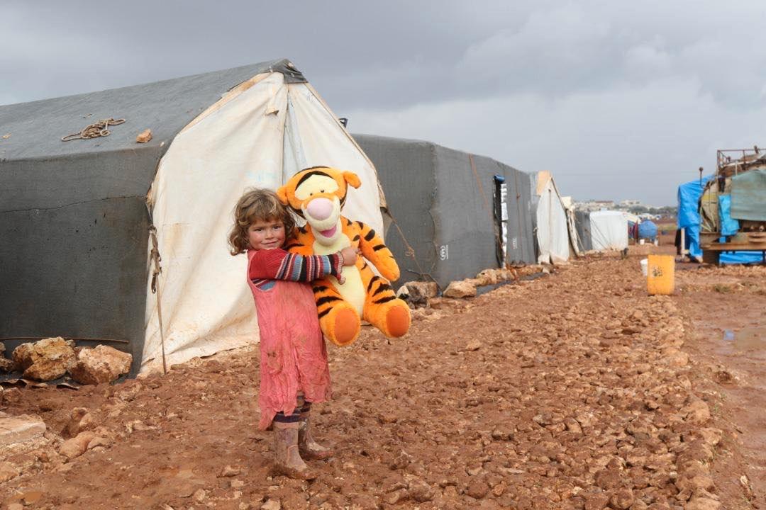 Khulod Khaled, 4 år, är föräldralös. Båda hennes föräldrar har dödats i kriget i Syrien. Genom Stand with Syria har hon fått ett eget gosedjur att bo med i det provisoriska flyktinglägret. 