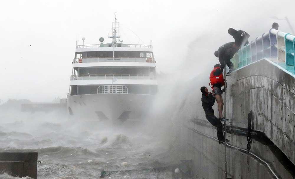 Räddningstjänst i Sydkorea hjälper besättningsmän från en färja i säkerhet.