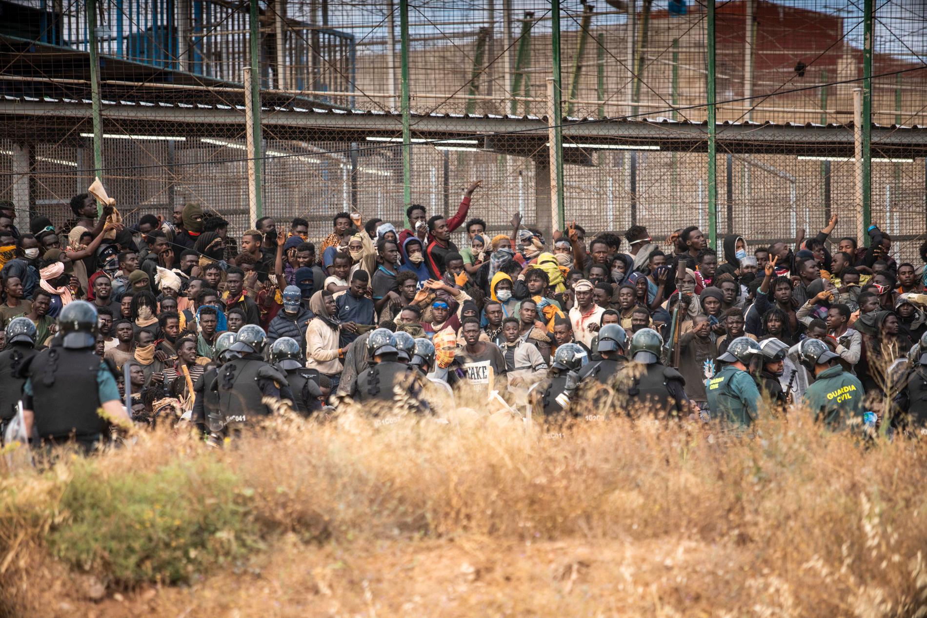 Kravallpoliser spärrar av området efter att migranter anlänt till spansk mark och korsat staketet som skiljer den spanska enklaven Melilla från Marocko i Melilla, Spanien.