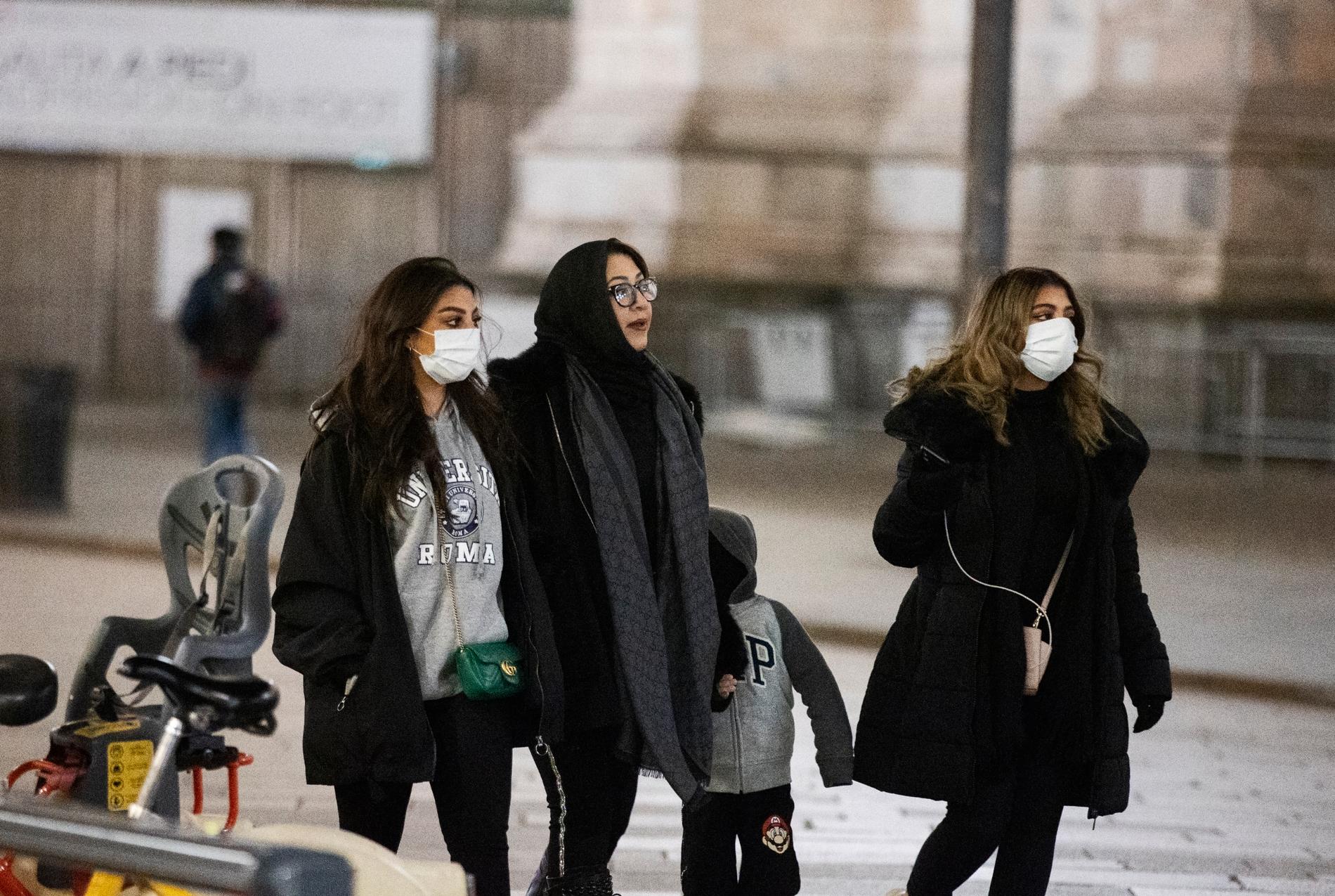 Coronaviruset har spridit sig i norra Italien. Människor med munskydd vid ett öde Piazza del Duomo i Milano.