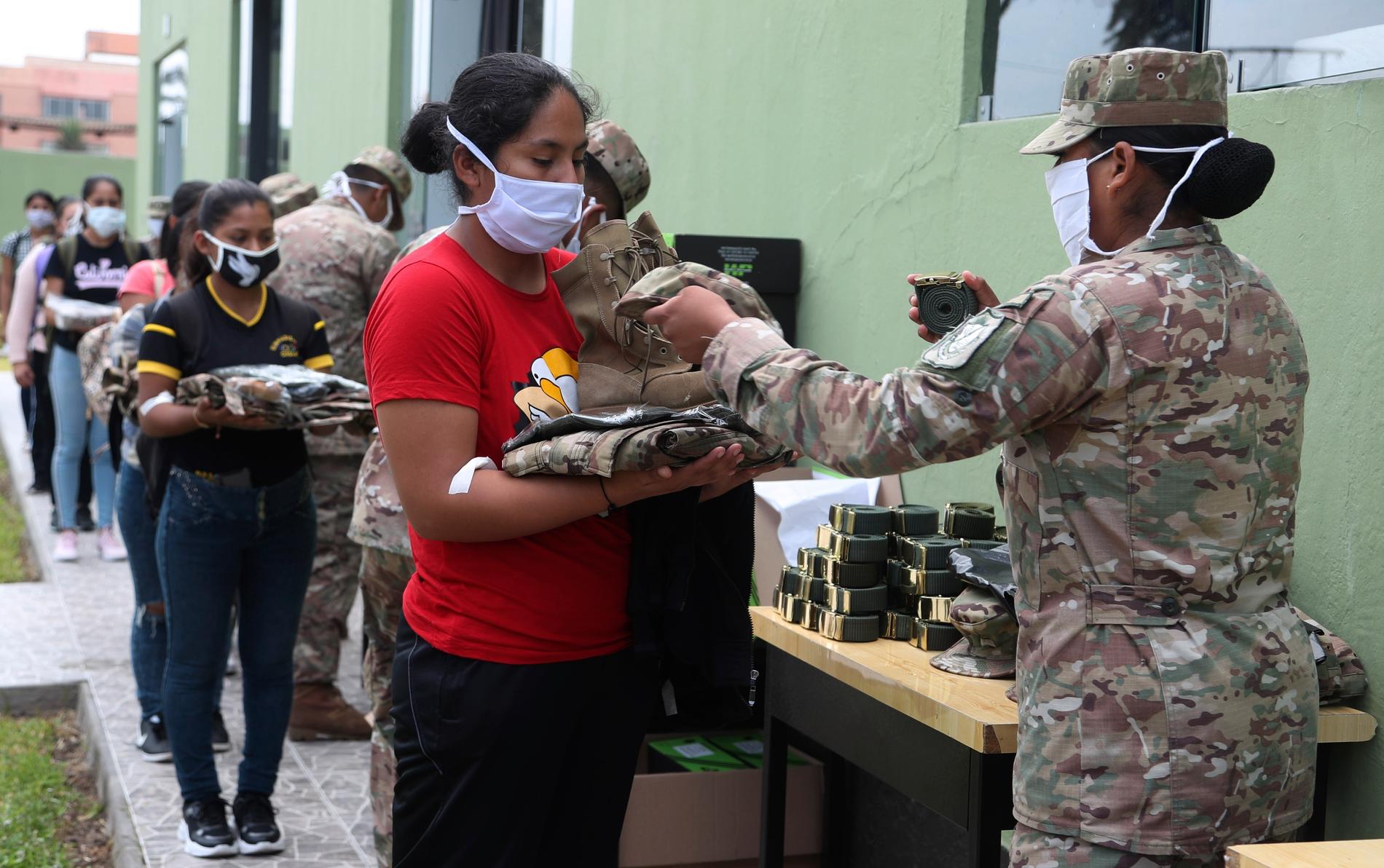 Soldater delar ut uniformer till reservister i Perus huvudstad Lima. Militärens och polisen kraftsamlar för att upprätthålla åtgärder som införts med anledning av coronaviruset.