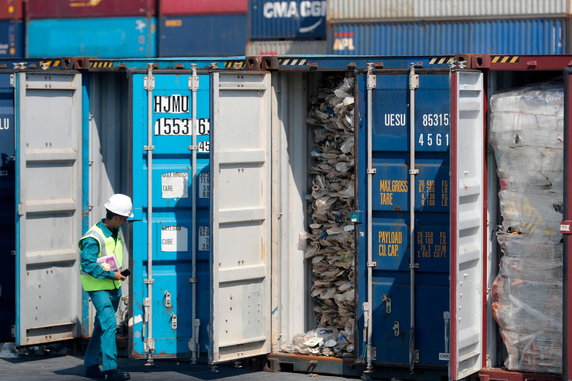 En malaysisk tjänsteman inspekterar en container full av plastavfall. Arkivbild.