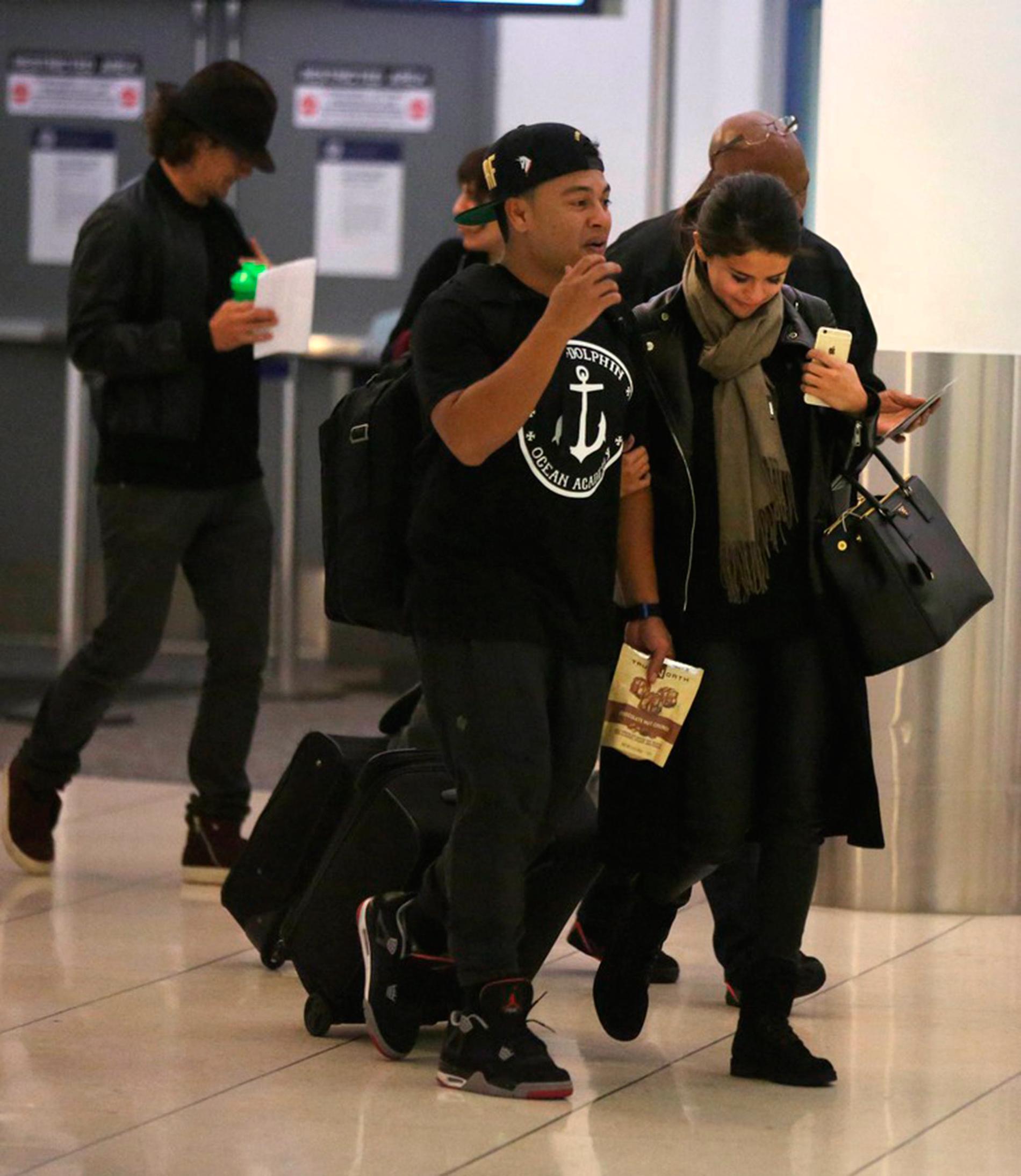 BILDBEVISET: Tittut! Orlando smyger bakom Selena på flygplatsen i Los Angeles.