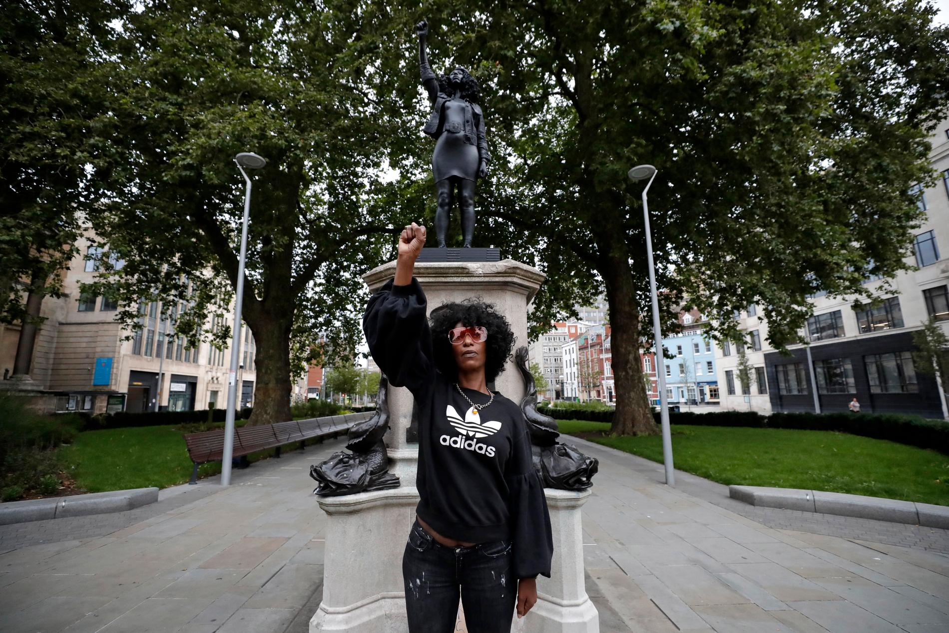 Black lives matter-demonstranten Jen Reid poserar framför statyn som hon stått modell för.