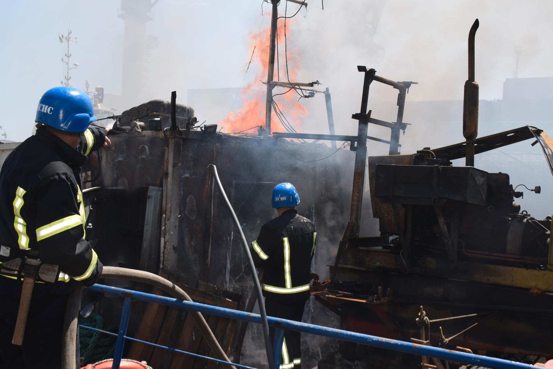 Brandmän släcker en brand i hamnen i Odessa under lördagen efter den ryska attacken.