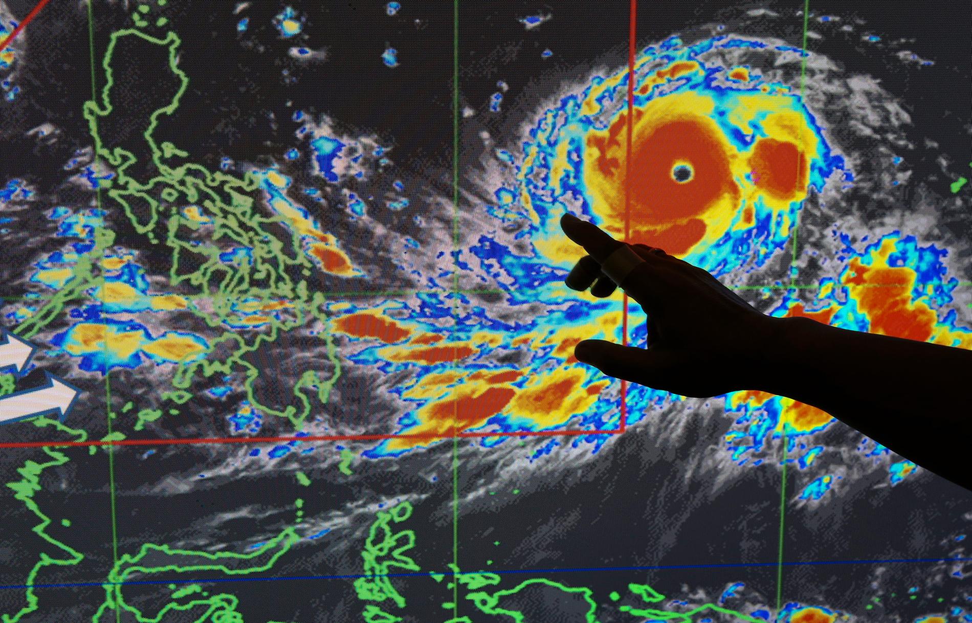 En meteorolog på Filippinernas vädermyndighet visar hur tyfonen Mangkhut väntas slå.