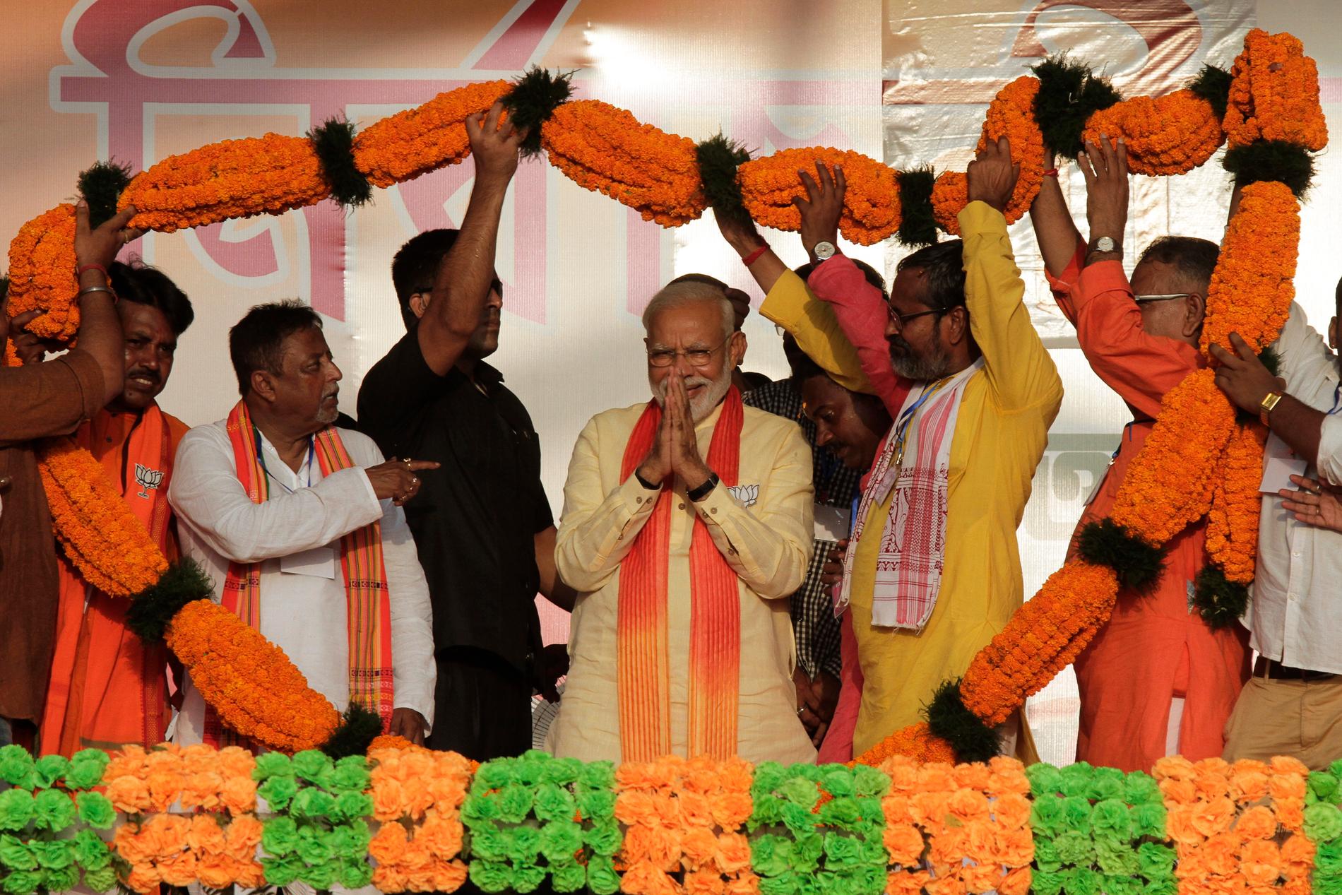 Indiens premiärminister Narendra Modi föräras med en enorm blomstergirlang vid ett valframträdande i Mathurapur i delstaten Västbengalen.