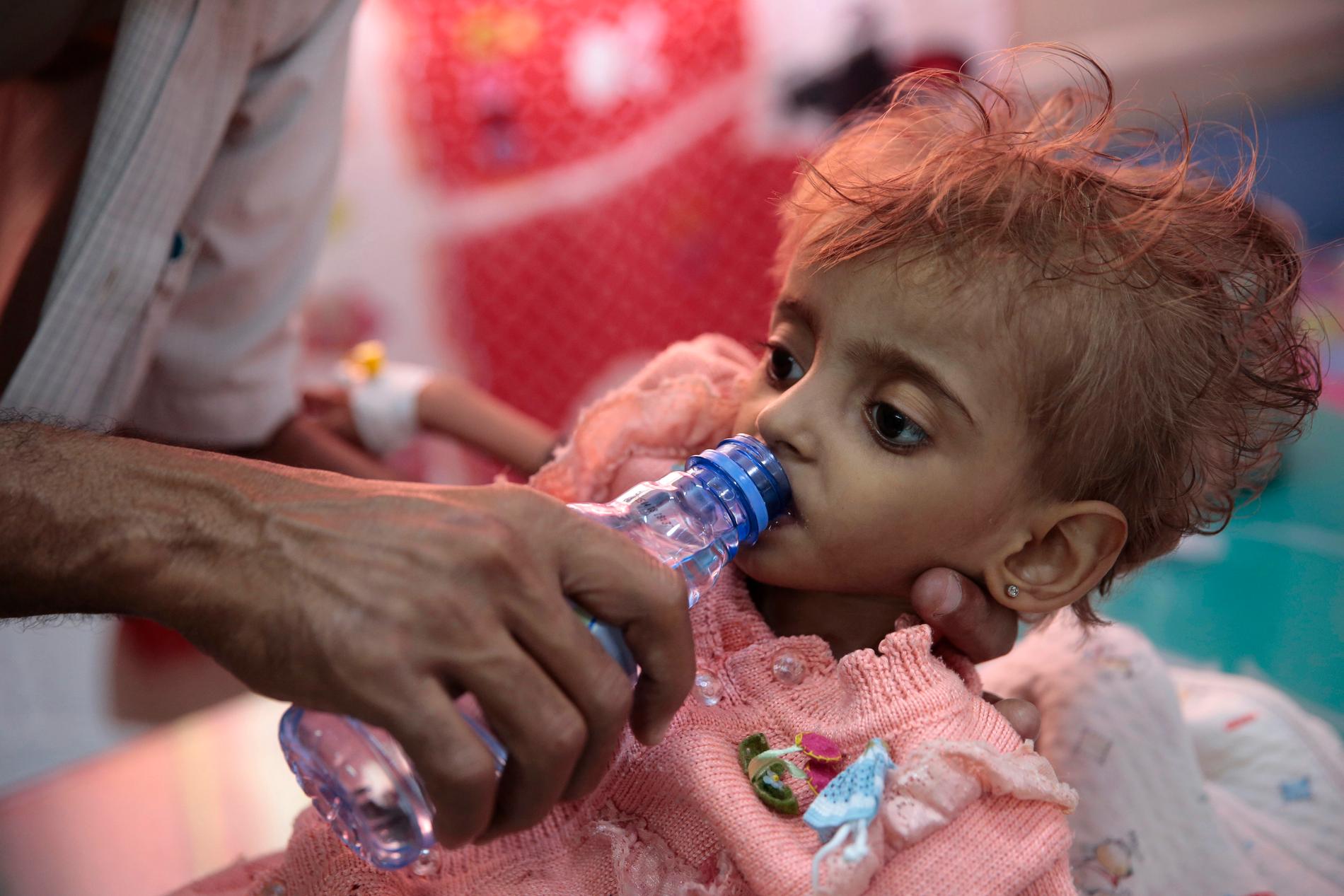 En pappa ger sin undernärda dotter vatten vid ett sjukhus i al-Hudaydah i Jemen. Bilden är från slutet av september. Arkivbild.