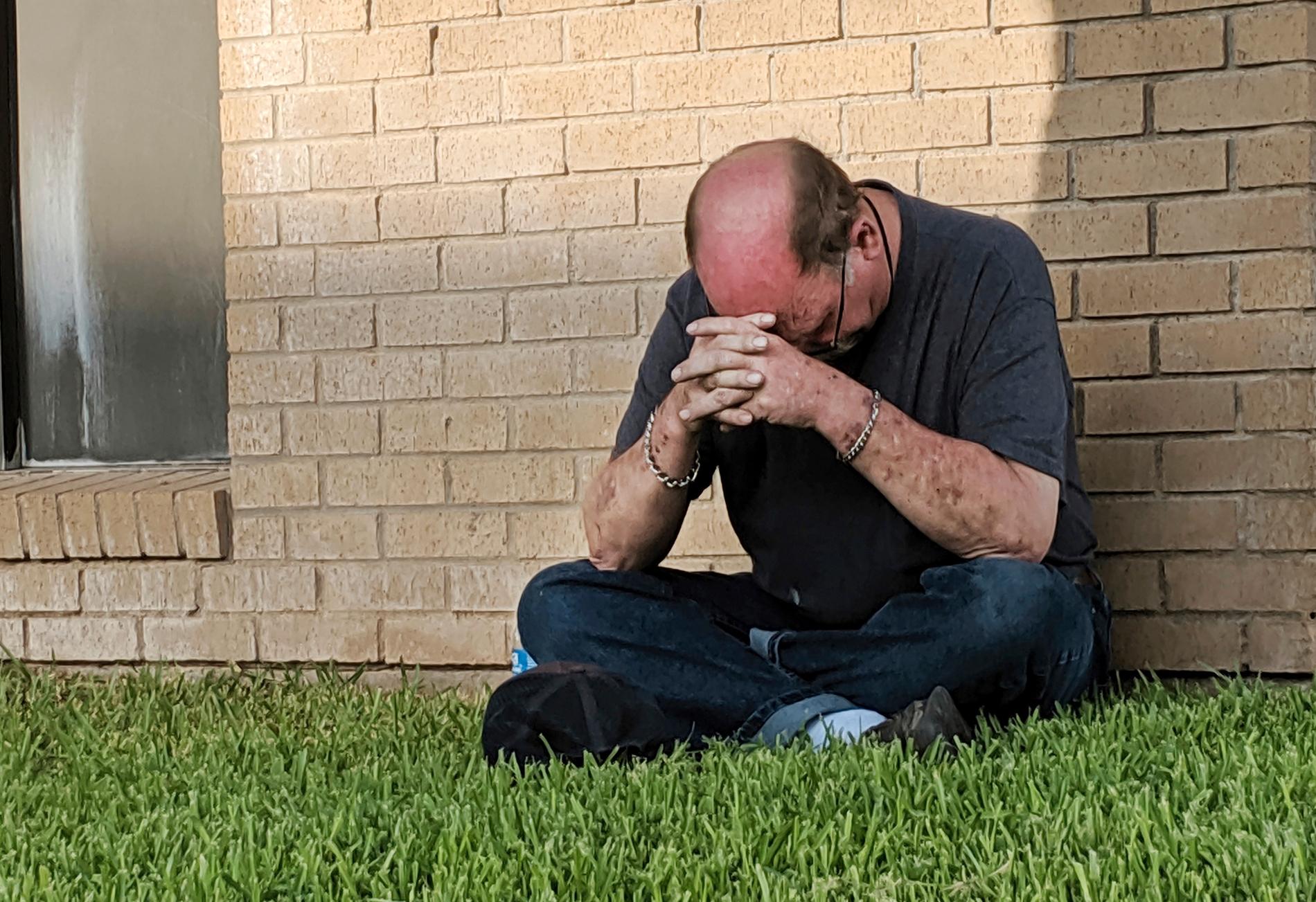 En man ber utanför en akutmottagning i Odessa, Texas, dit flera skadade fördes.