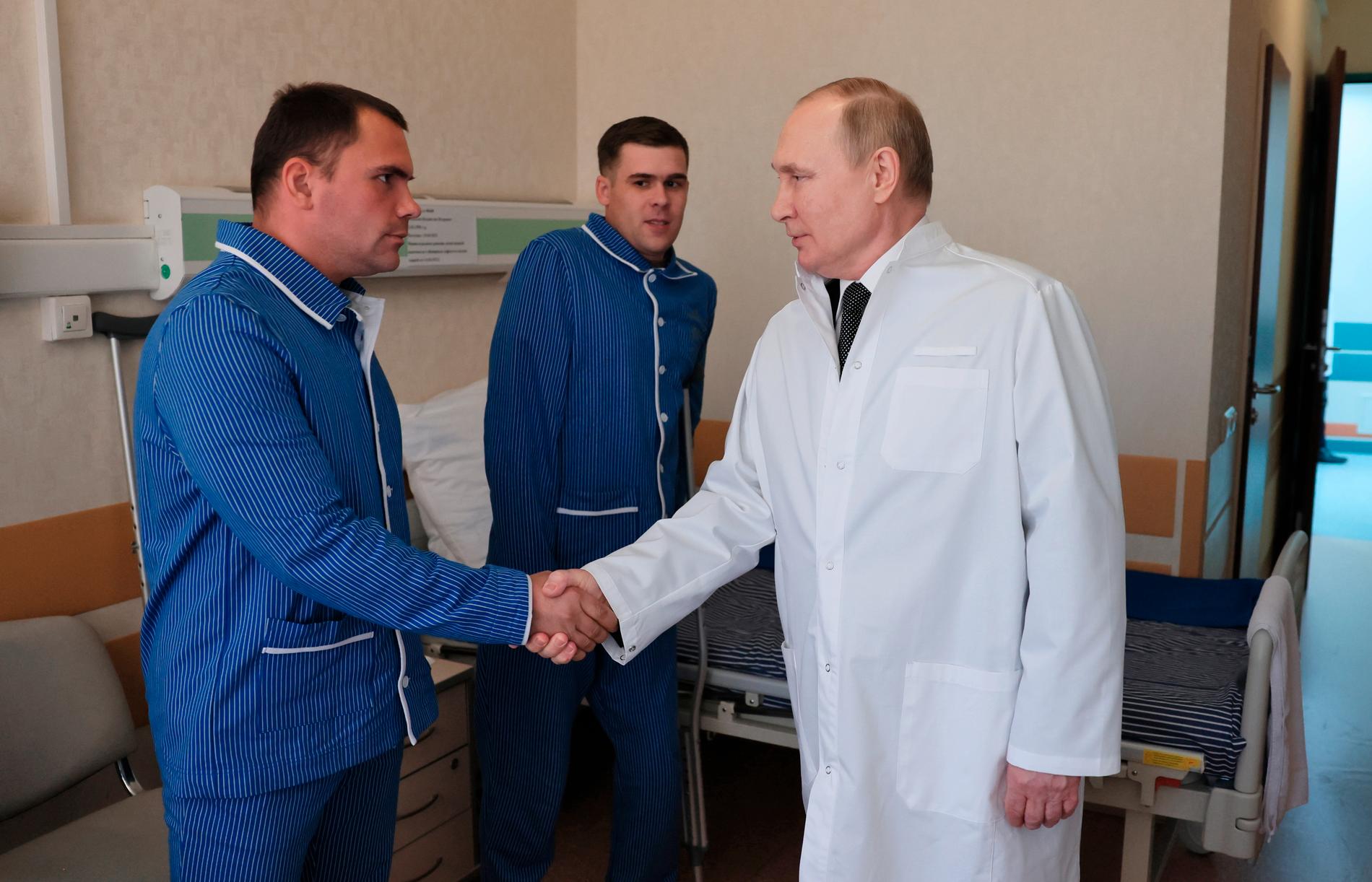Här hälsar Putin på soldater i armépyjamas.