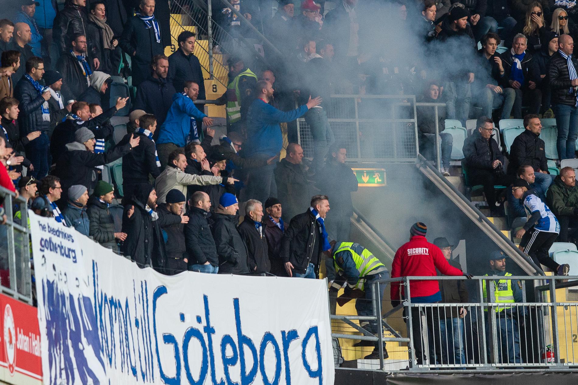 En bengal tas om hand efter att en Hammarbysupporter (ej i bild) kastat in den mot IFK Göteborgs supportrar under fotbollsmatchen.