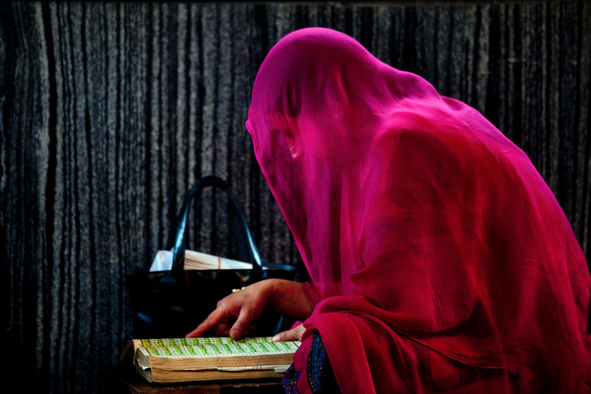 En muslimsk kvinna läser ur koranen.