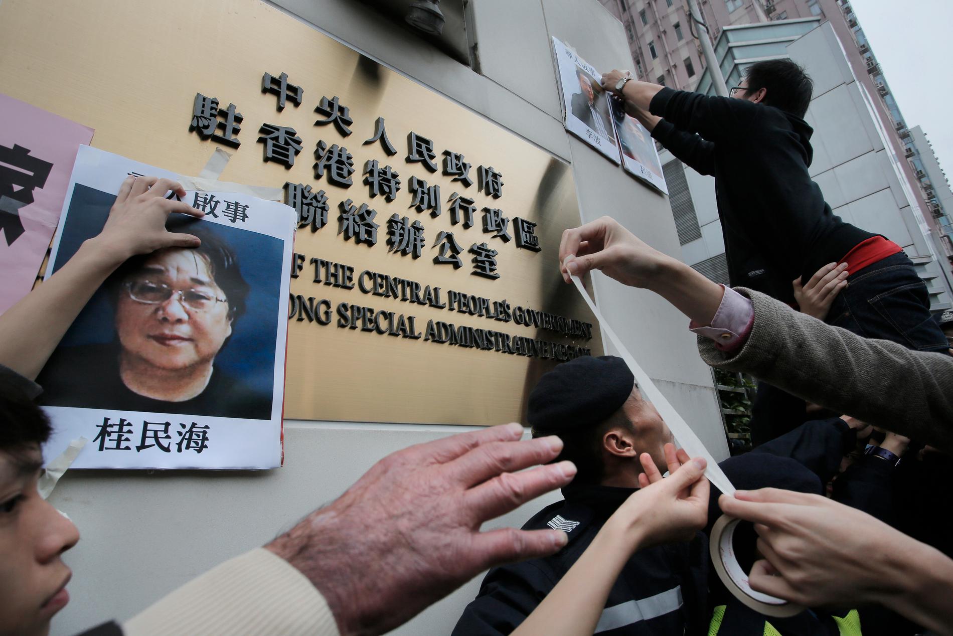 En bild på den av Kina fängslade förläggaren Gui Minhai sätts upp på en vägg i samband med en protestaktion i Hongkong 2016.