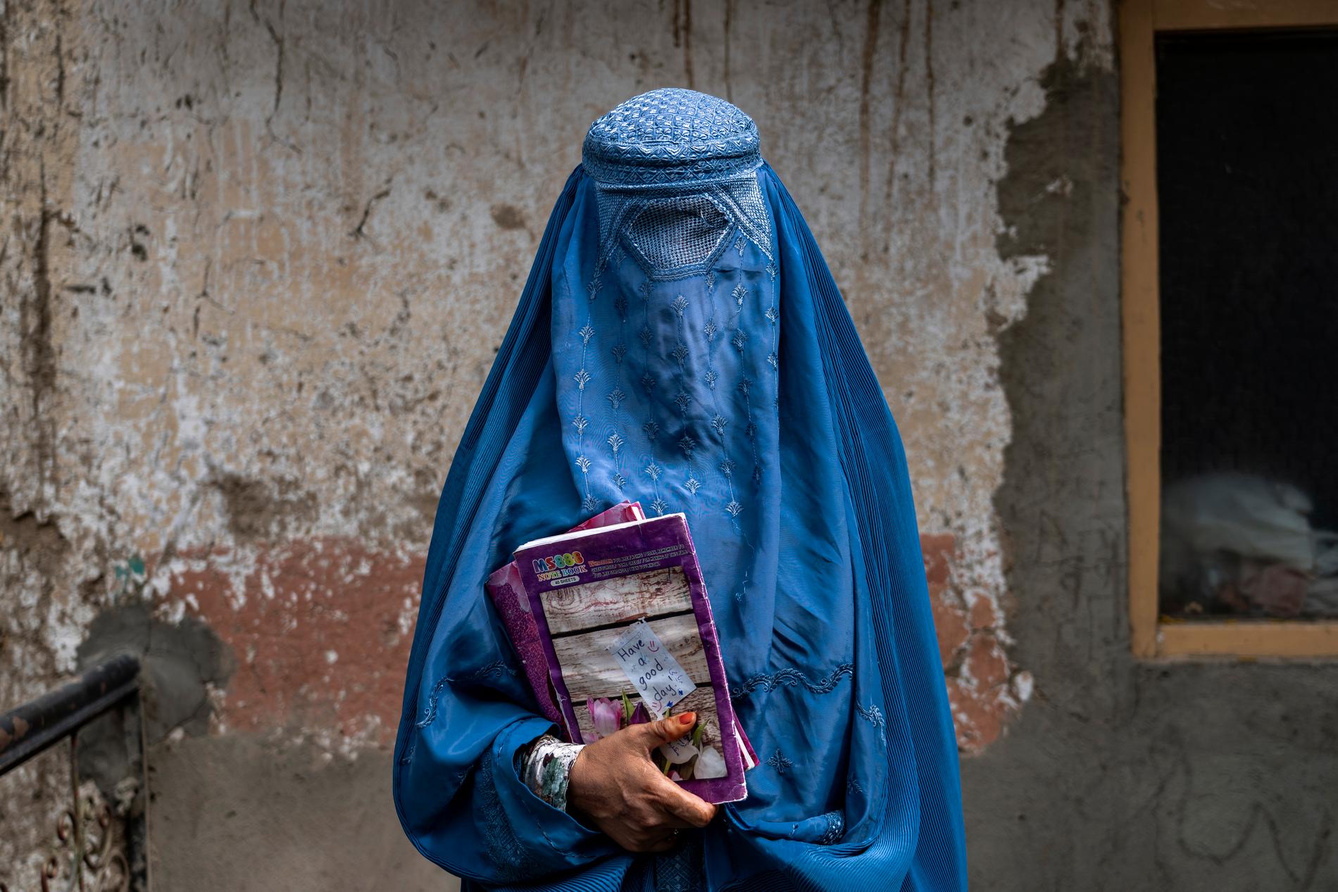 Kvinna lämnar en skola i Kabul som hålls gömd. 