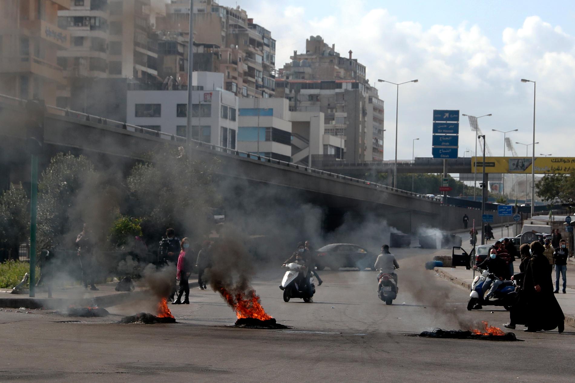 Demonstranter bränner däck för att blockera en väg i Beirut i Libanon.
