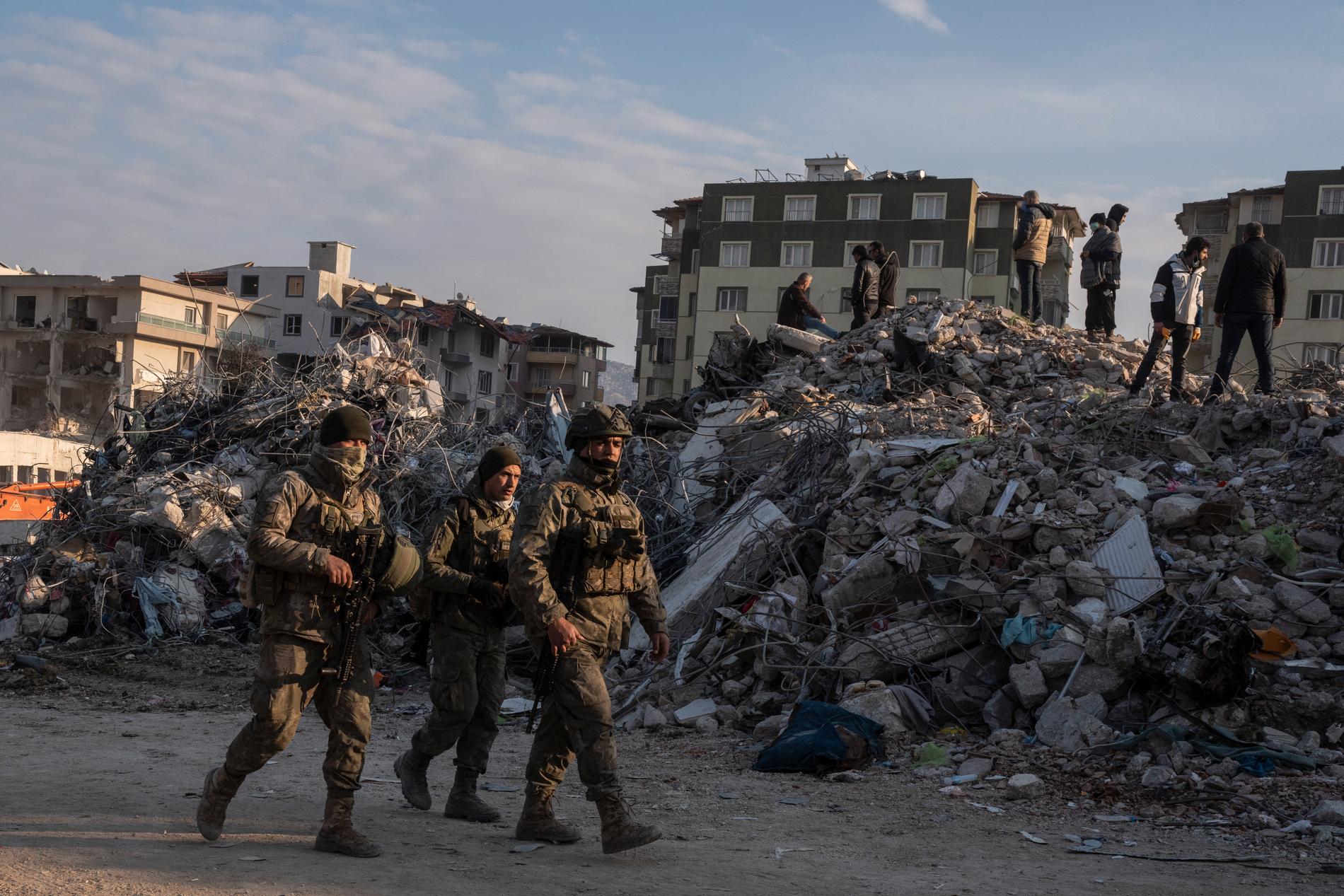 Turkisk militär patrullerar i Antakya samtidigt som räddningsarbetare letar efter överlevande under lördagen.