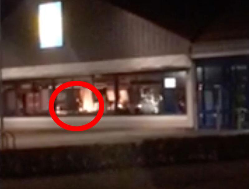På filmklipp syns hur mannen rör sig inne i butiken medan det brinner.