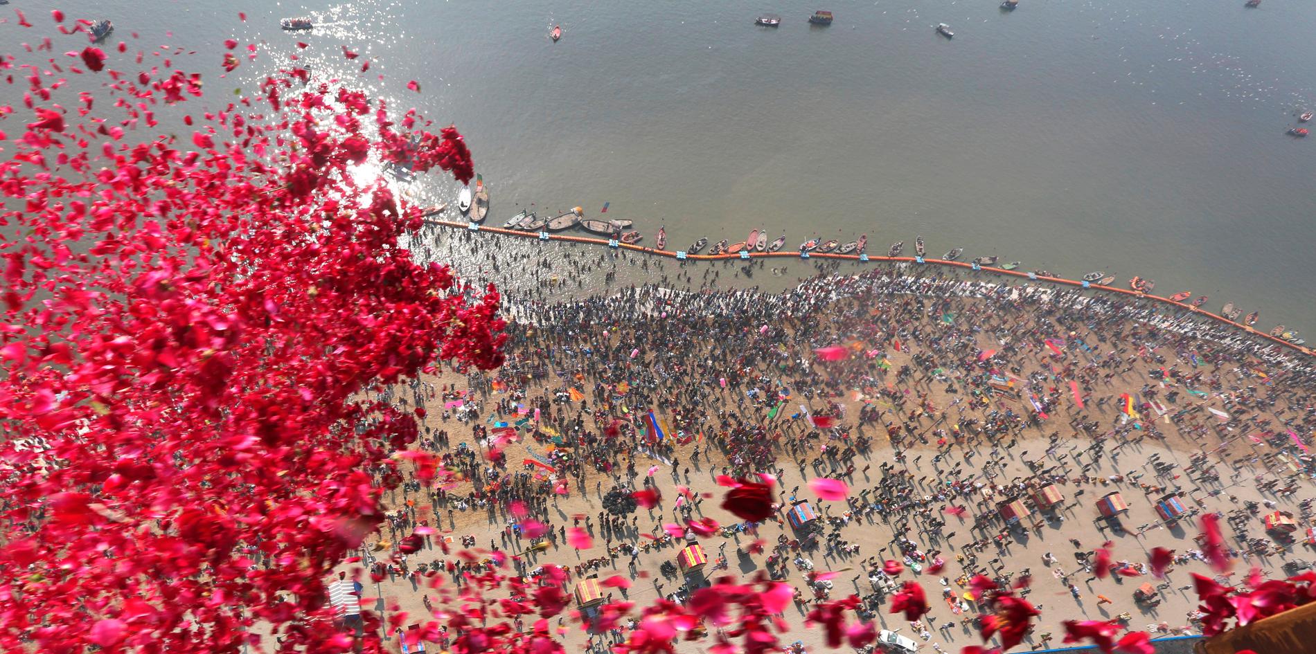 Den religiösa högtiden kumbh mela, då miljontals pilgrimer badar i främst den heliga floden Ganges, pågår i den indiska delstaten Uttar Pradesh. Bilden visar rosenblad som delstatsstyret under måndagen släppte över deltagarna.