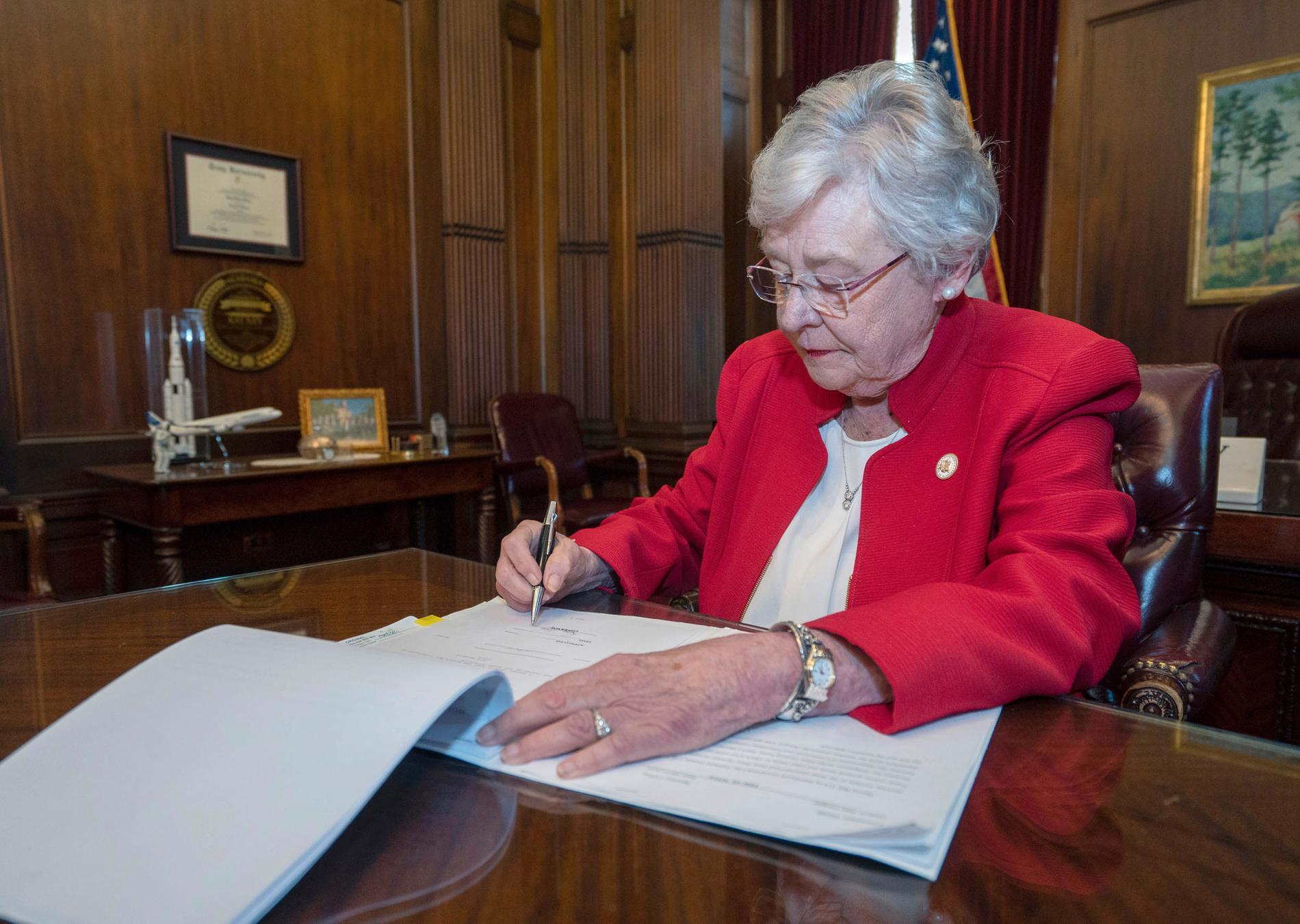 Alabamas guvernör Kay Ivey skriver under lagförslaget. 