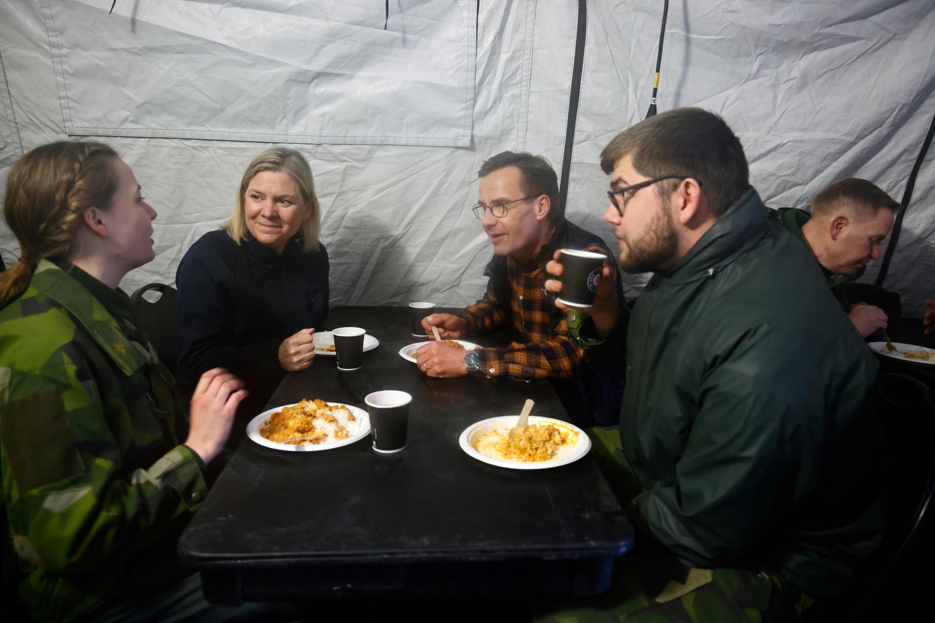 Statsminister Magdalena Andersson (S) och Moderaternas partiledare Ulf Kristersson (M) pratar med två deltagare i den internationella militärövningen Cold Response.